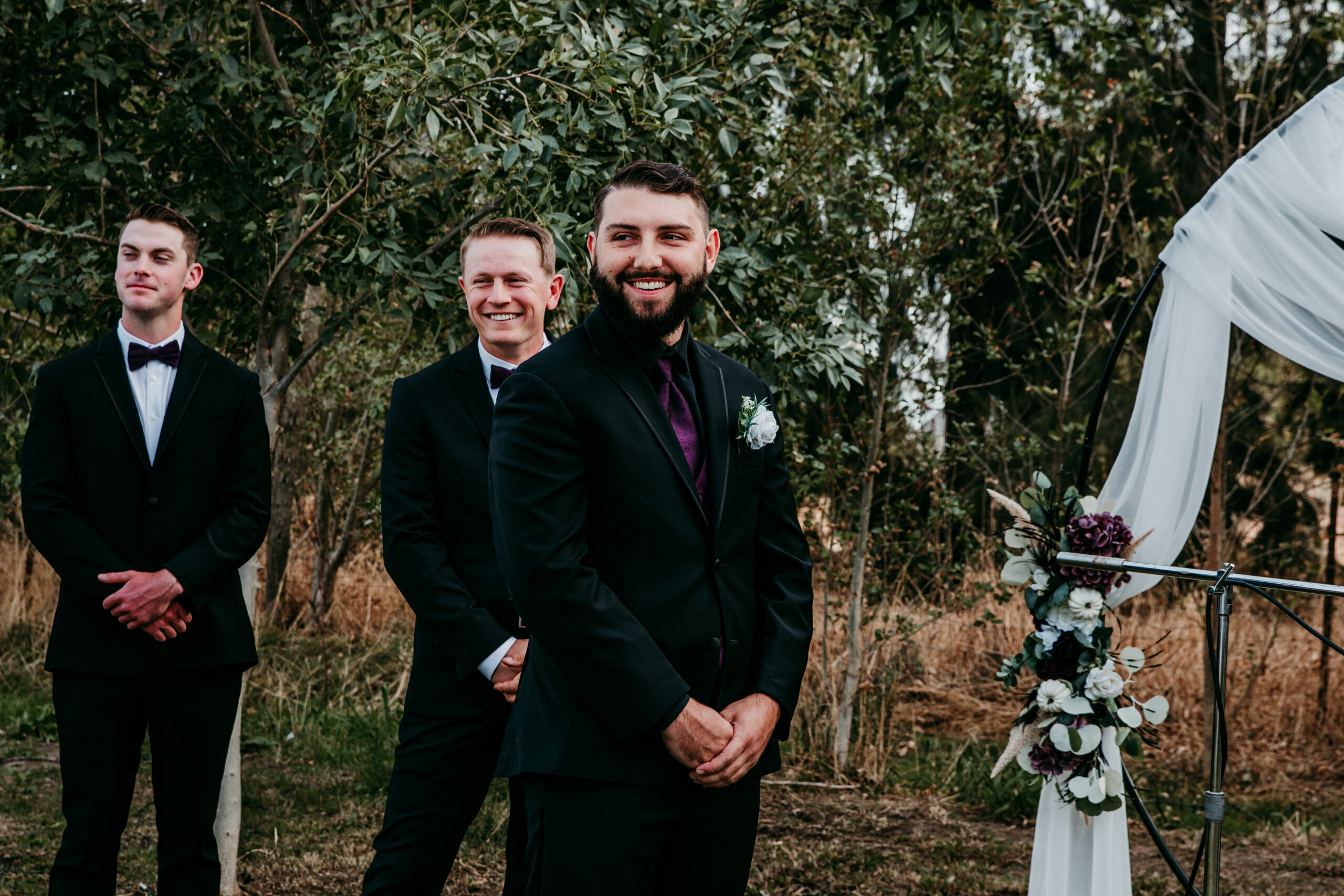 Groom smiling with his best man standing behind him before the ceremony at a backyard wedding in Vacaville, CA