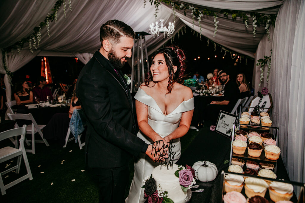 Bride and groom cutting their cake under a tent during their elegant backyard wedding in Vacaville, CA, captured by Bay Area wedding photographer.