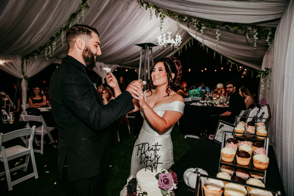 Groom feeding his bride a piece of cake during their Vacaville reception, a sweet moment caught by Bay Area wedding photographer.