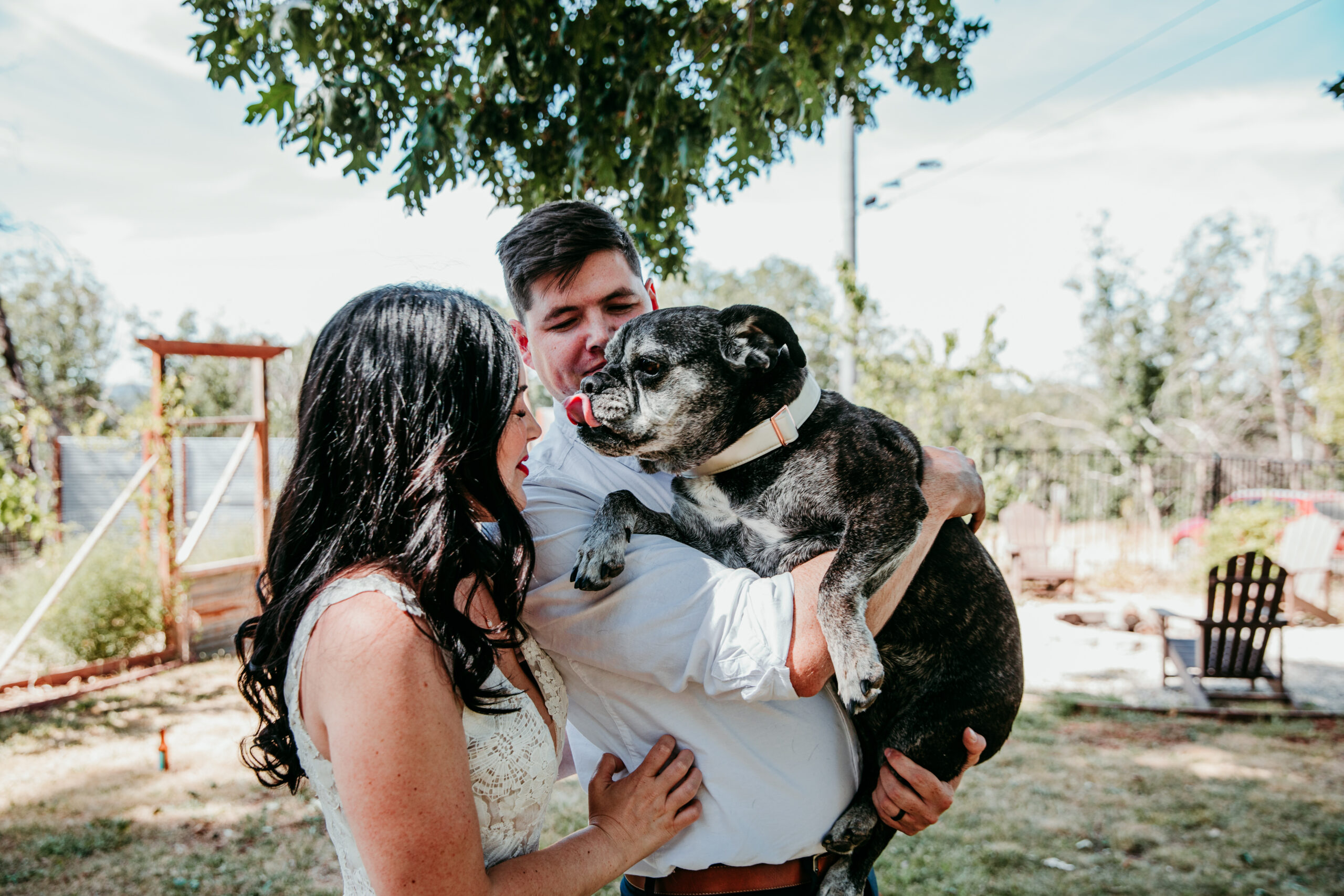 Bride and groom cuddle their dog after their intimate backyard wedding in Grass Valley CA, captured by a local elopement photographer.