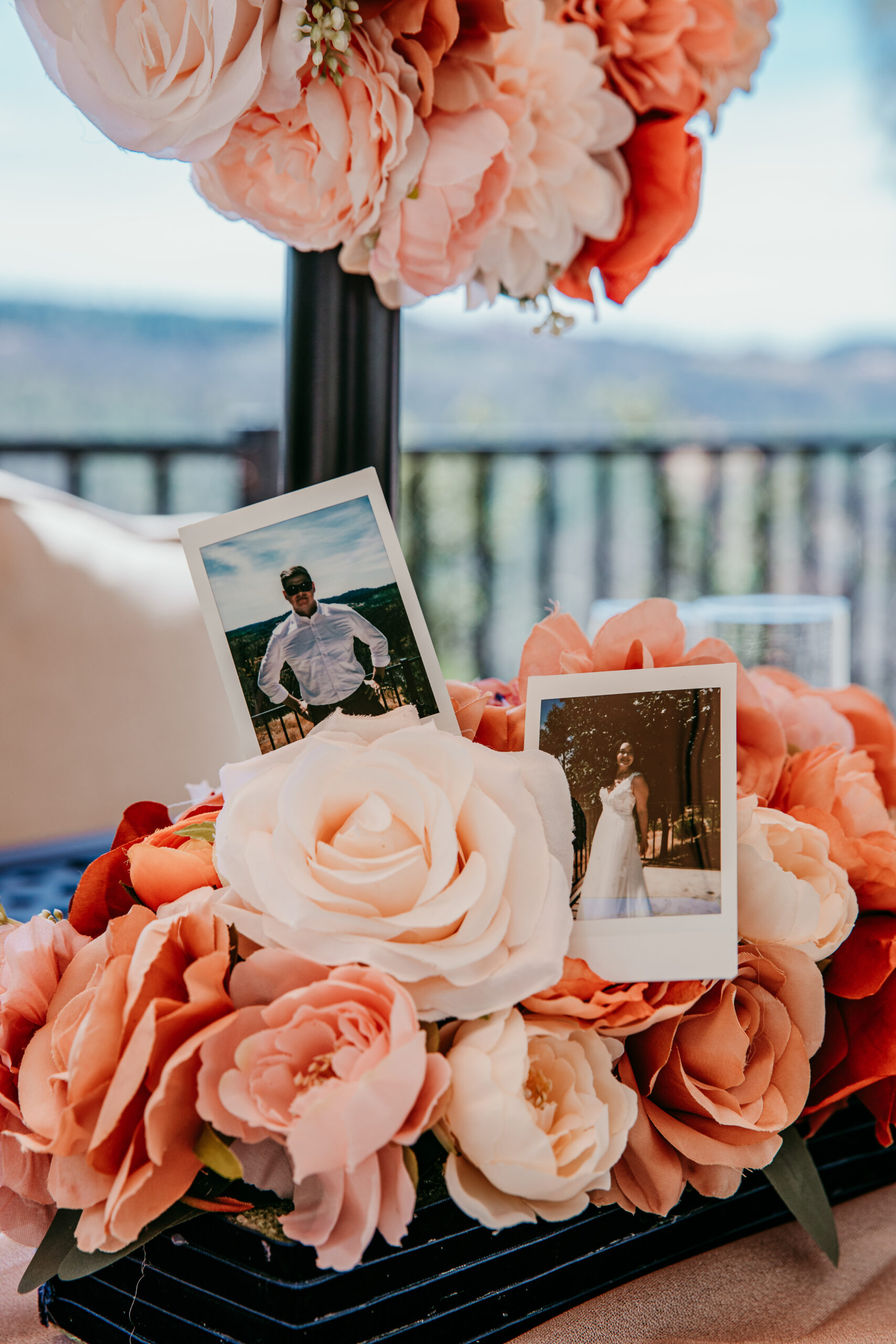 Close-up of peach-toned wedding flowers with Polaroid photos of the couple at their Northern California elopement.