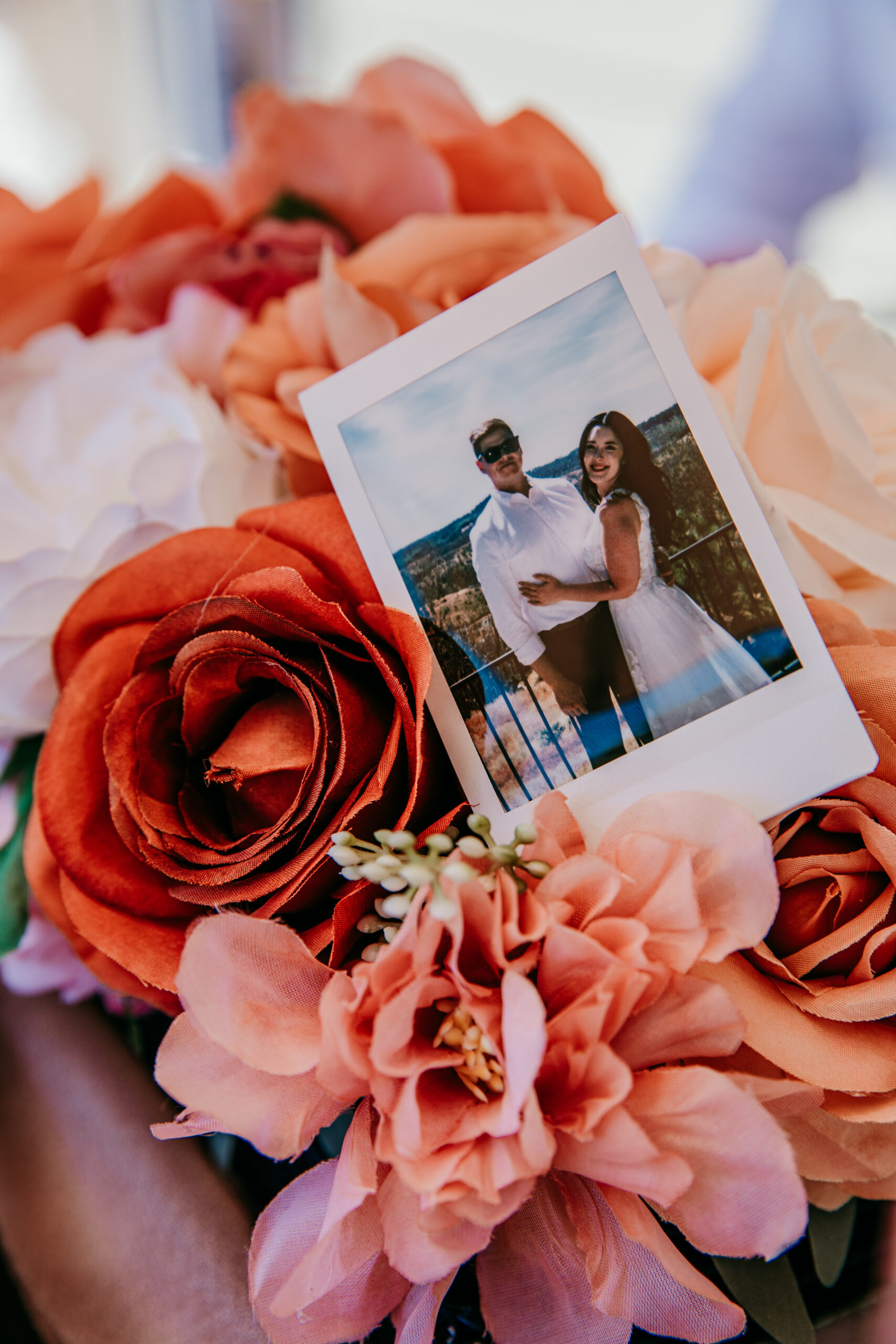 Polaroid of the couple displayed on peach and terracotta florals during their Northern California elopement brunch celebration.