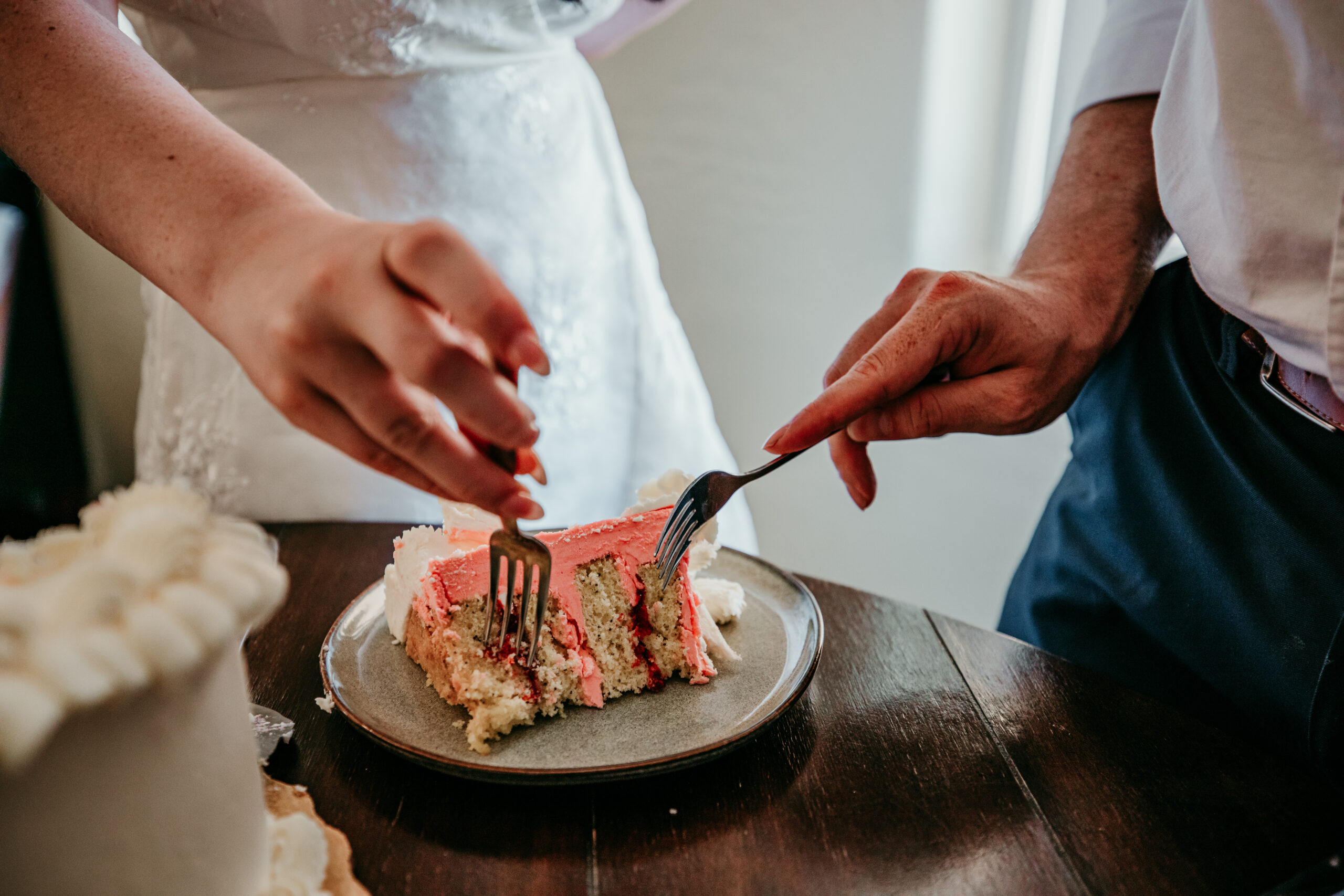 Close-up of a cake slice with unexpected pink filling during a Northern California elopement, as the couple shares a laugh over the surprise.