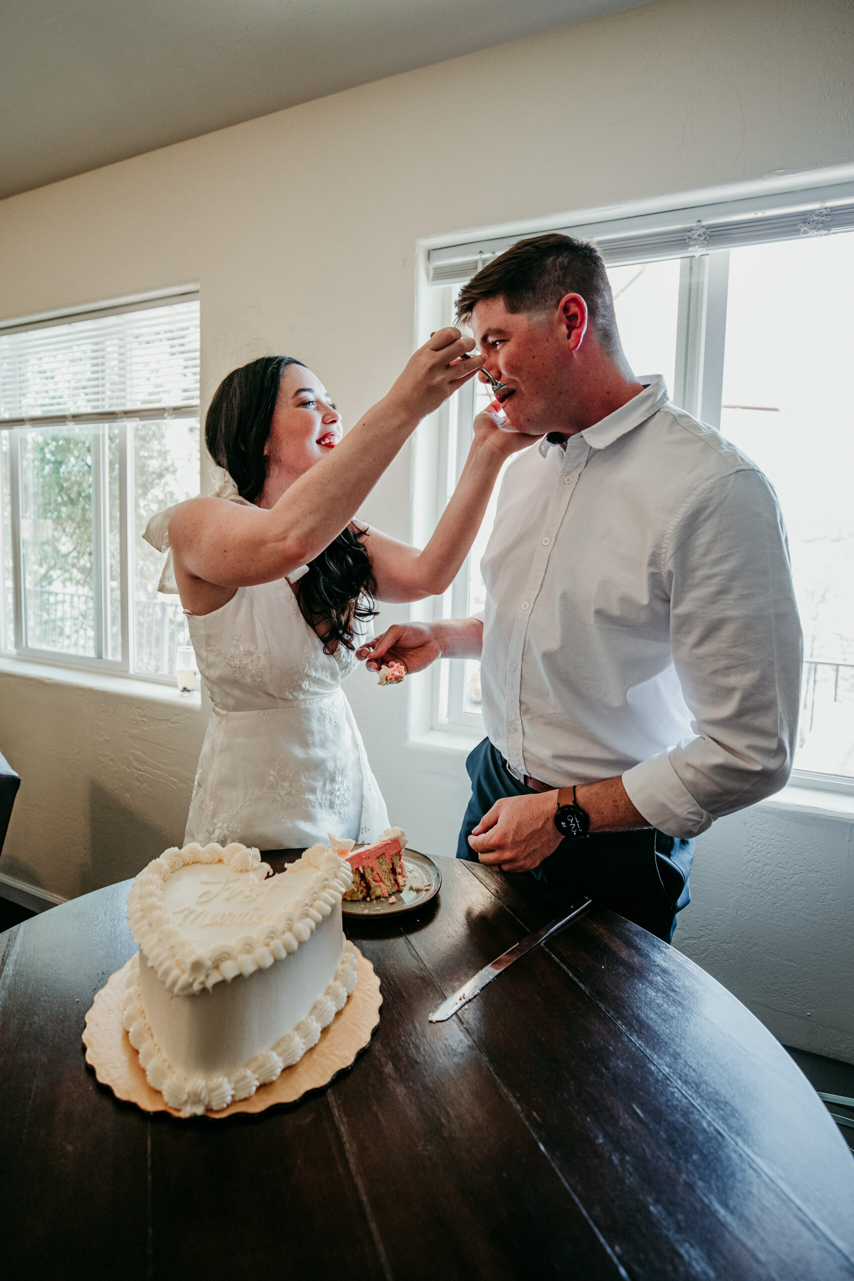 Bride feeding her groom a slice of cake while laughing during their intimate Northern California elopement.