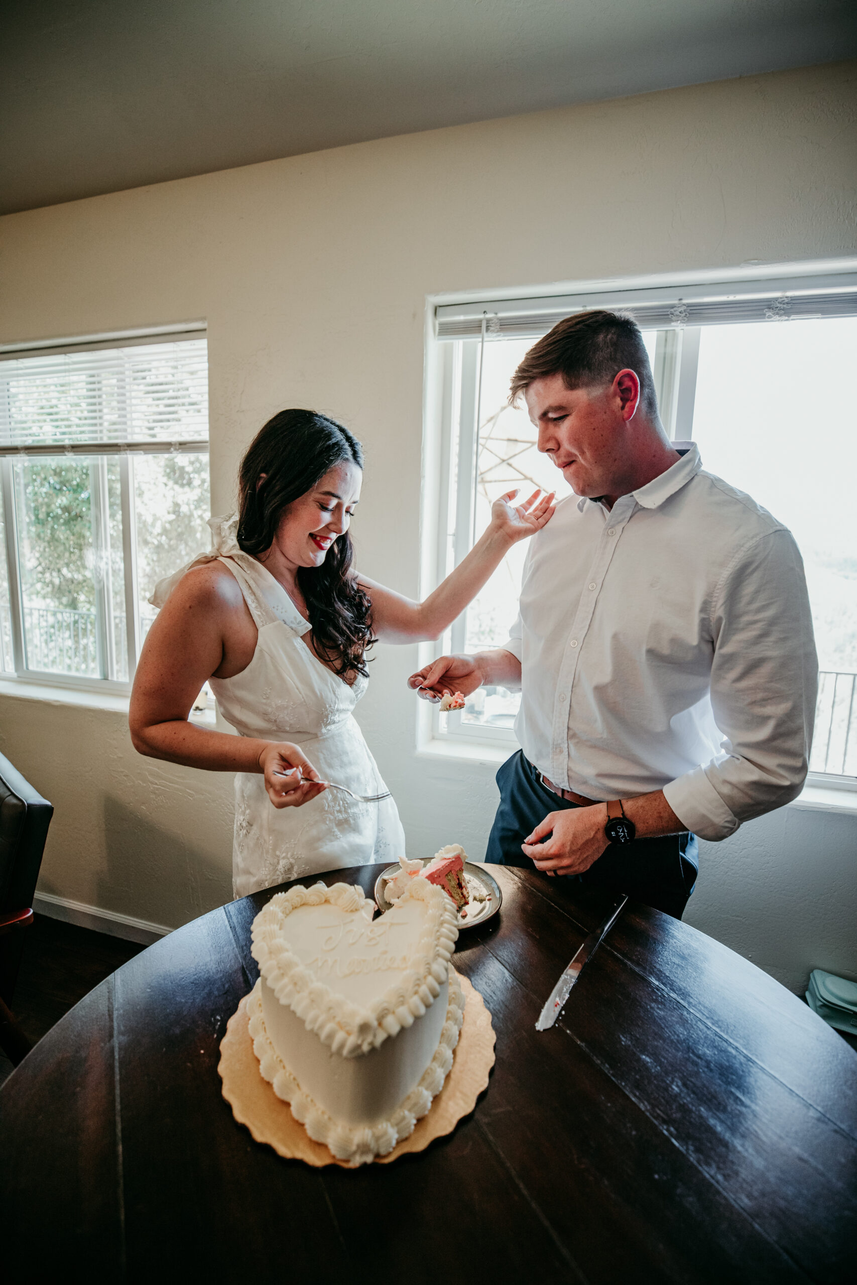 Bride and groom share a lighthearted moment with cake during their relaxed Northern California elopement at an Airbnb.