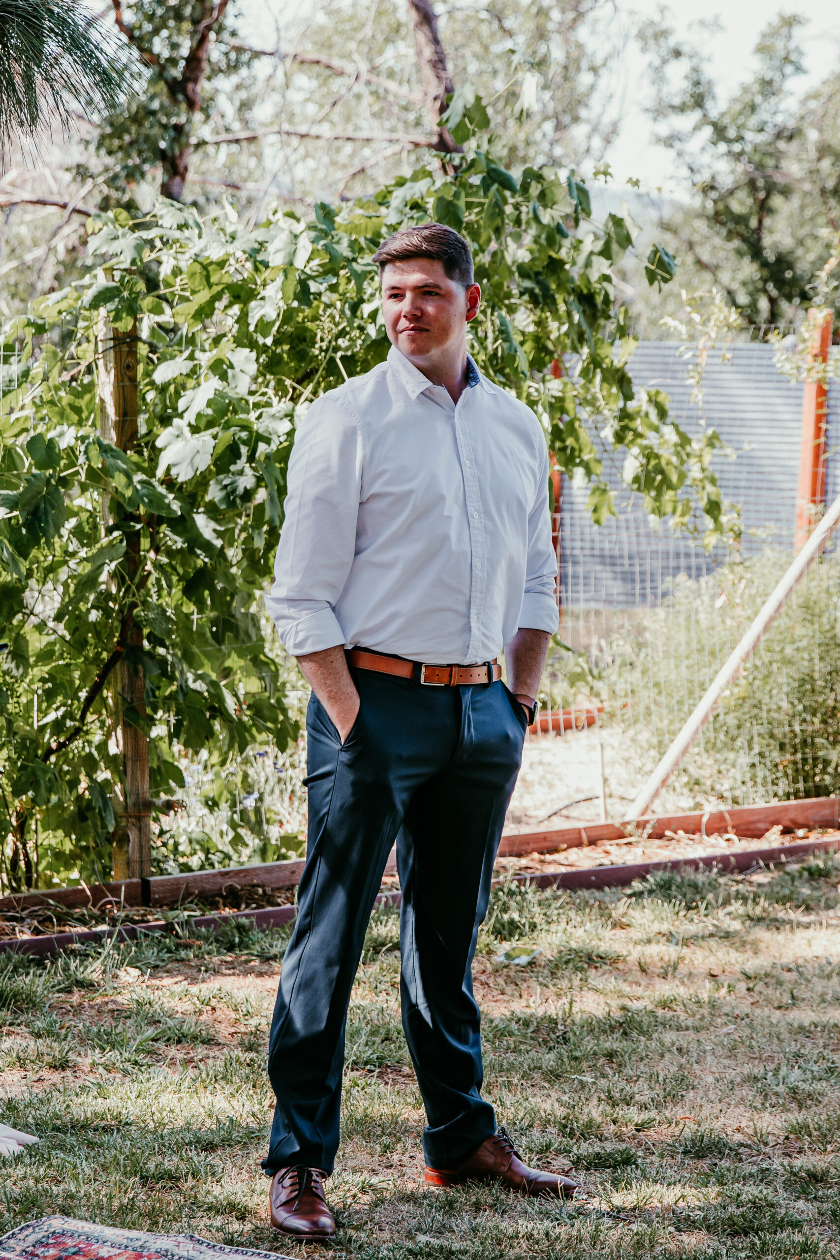 Groom standing in the shade before the ceremony at a relaxed Airbnb elopement in Grass Valley CA.