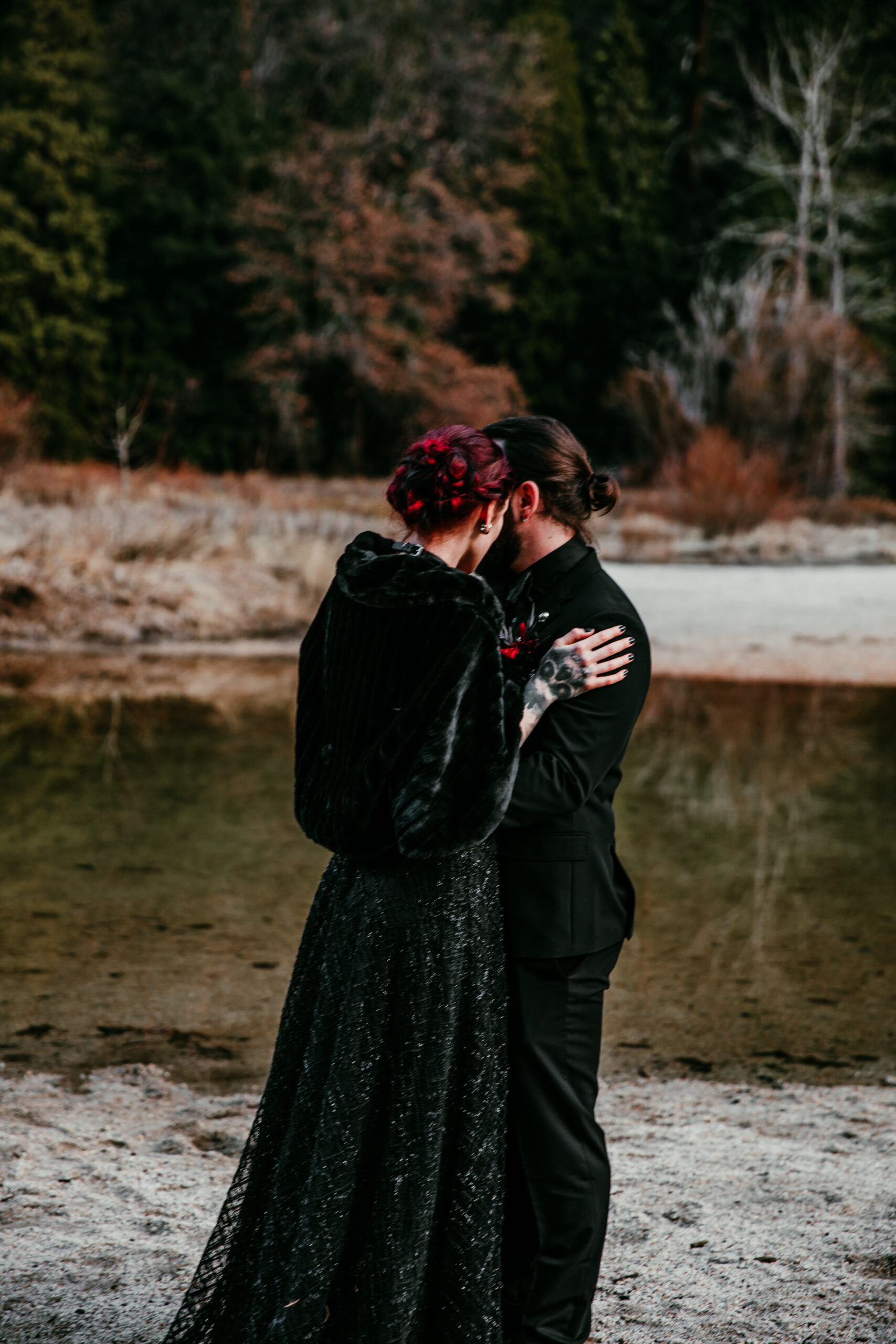 Eloping couple sharing a kiss by the lake, showing why couples elope for quiet, meaningful moments surrounded by nature.