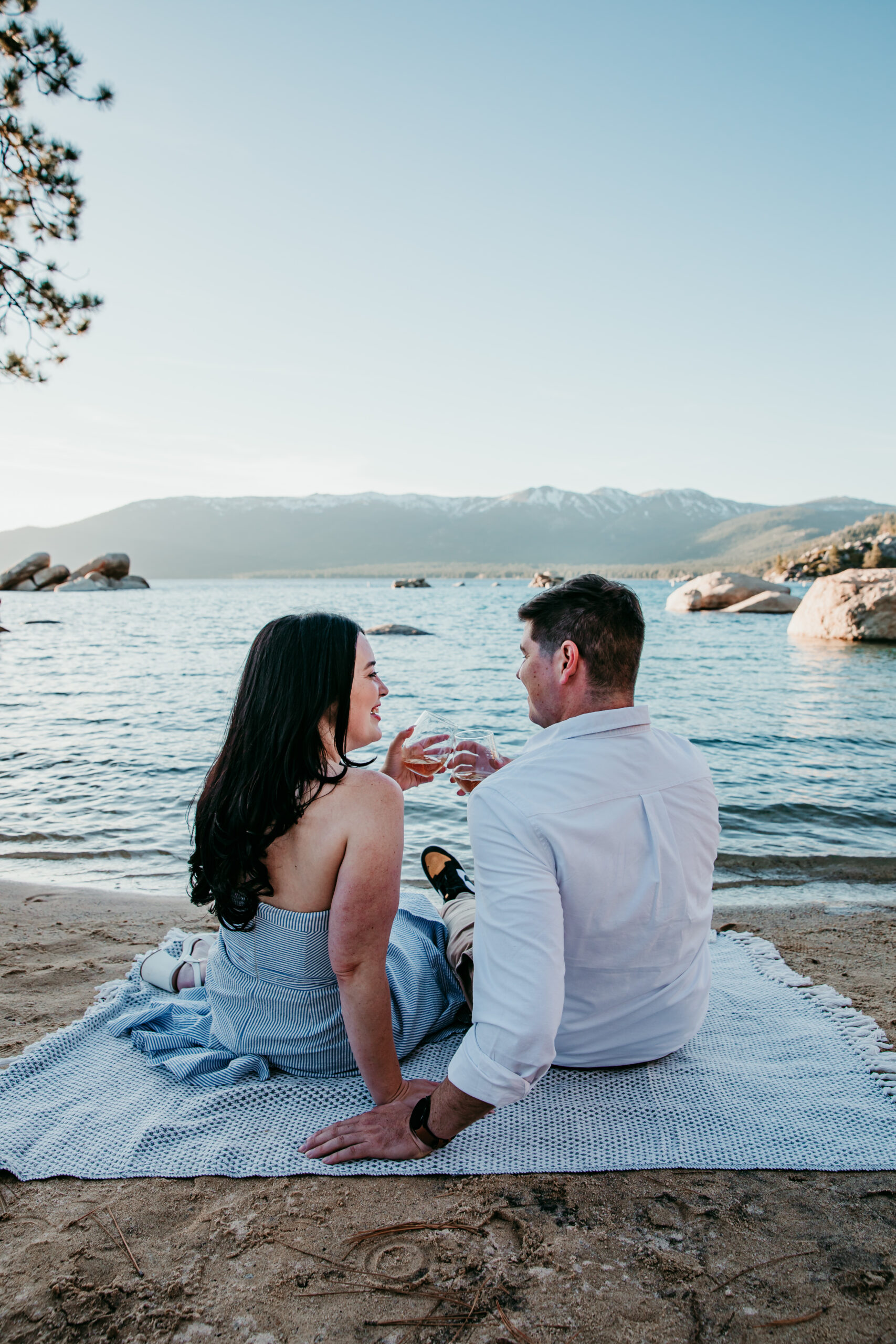 Couple enjoying a drink by the water at Lake Tahoe, a perfect example of how to elope in California with a relaxed and scenic lakeside moment.