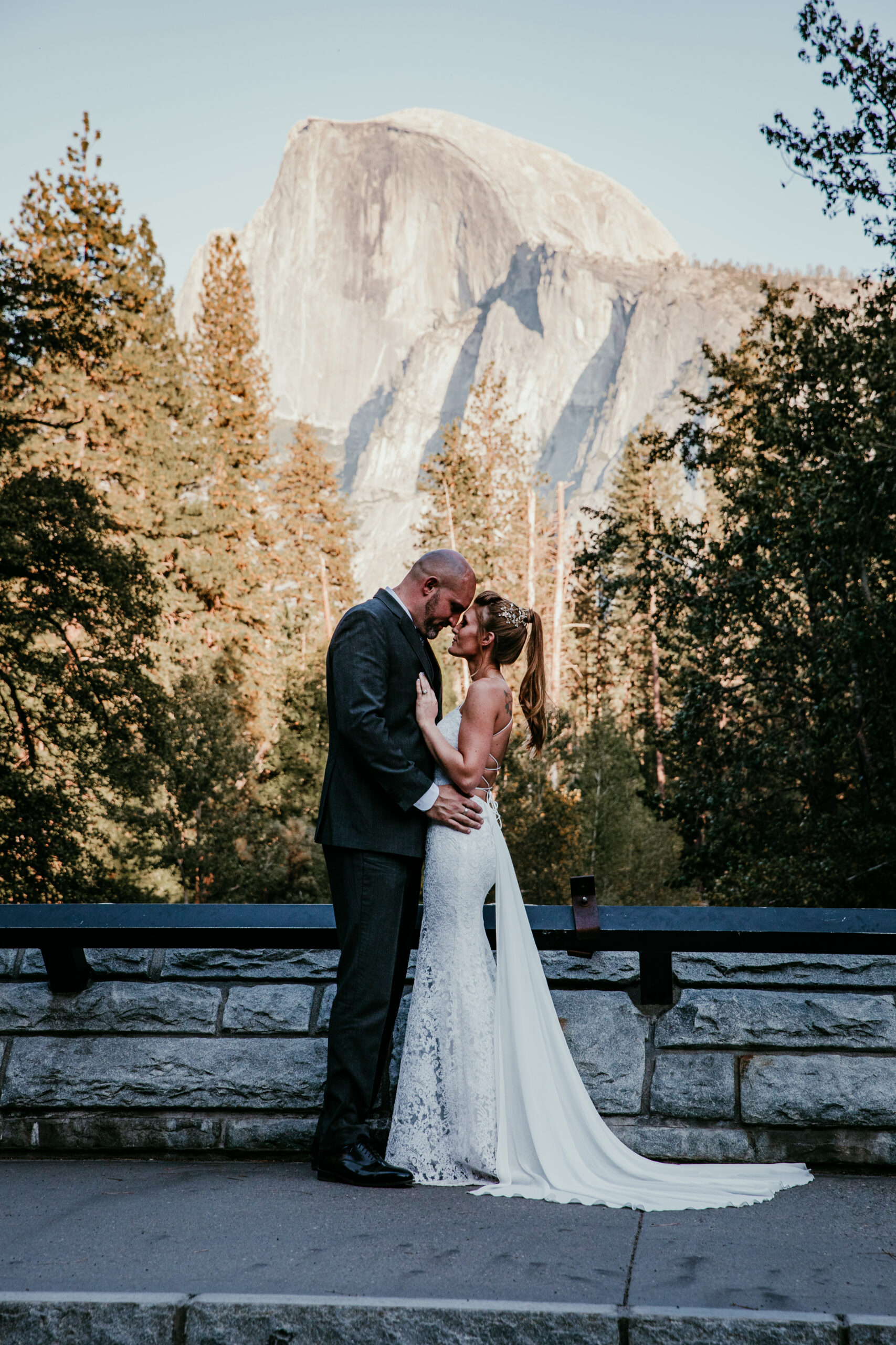 Bride and groom sharing a kiss with Half Dome in the background, showing how to elope in California with iconic Yosemite National Park views.