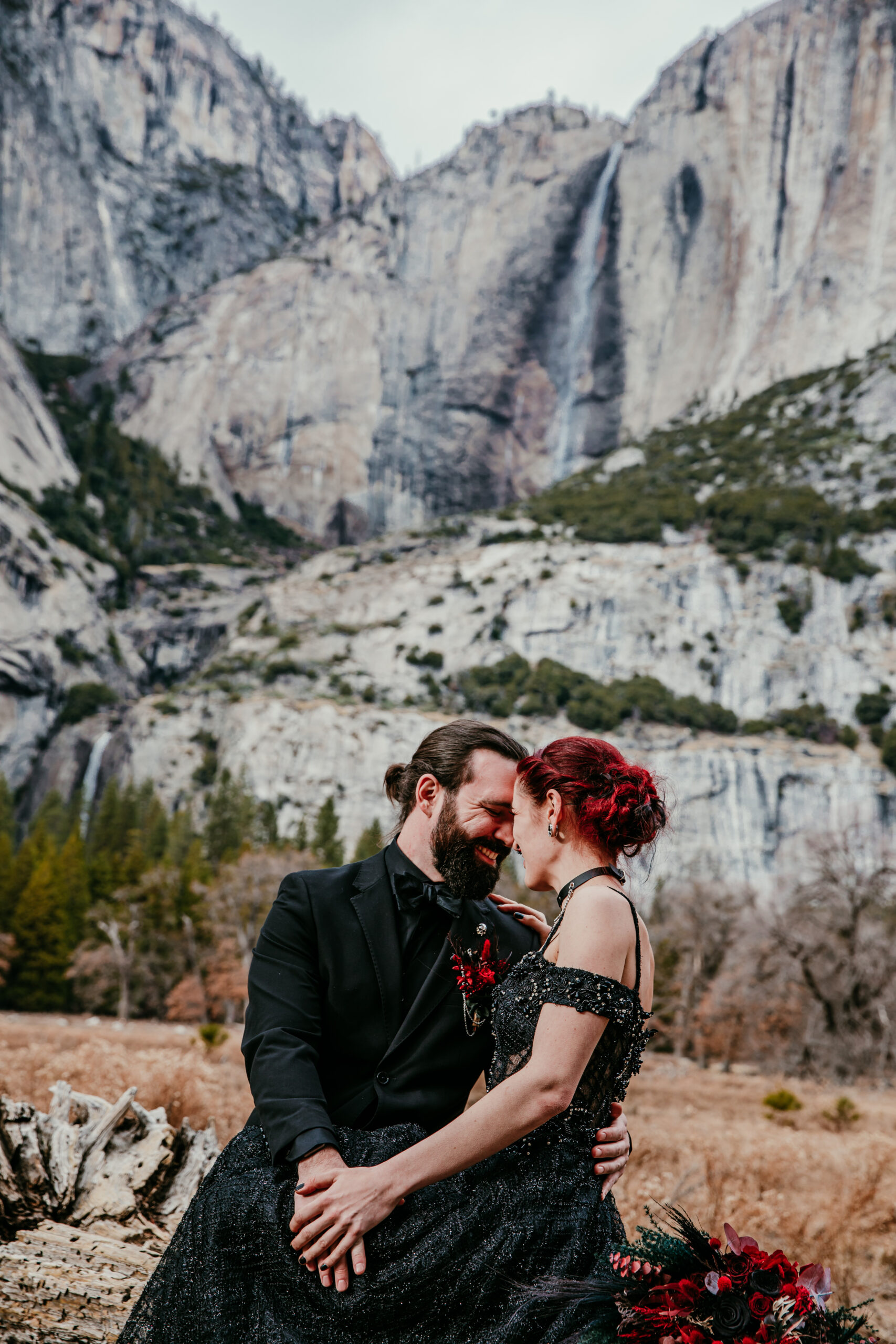 Romantic moment between a couple in black elopement attire in Yosemite Valley, capturing how to elope in California with dramatic mountain views.