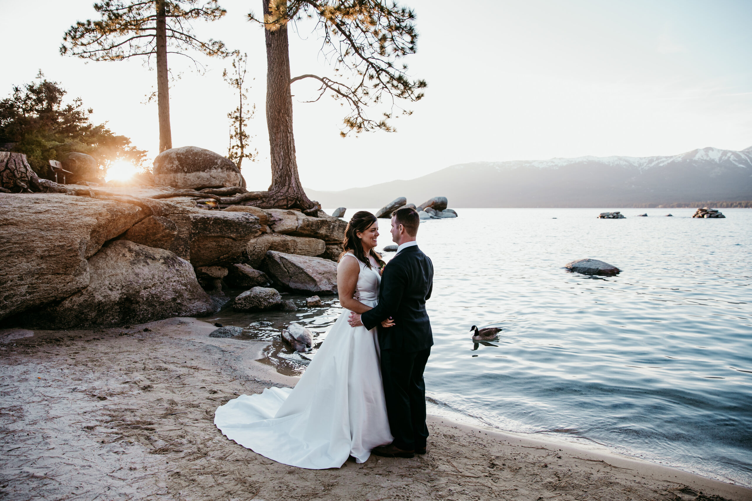 Bride and groom embracing at sunset along the shore—how to get married at Sand Harbor with a peaceful, scenic Lake Tahoe backdrop