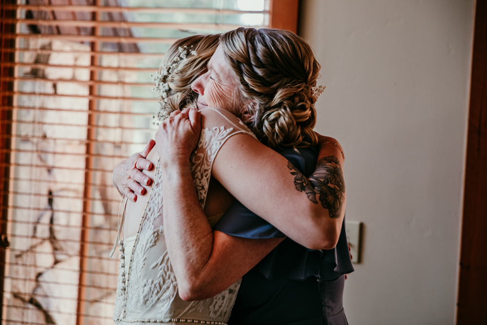 Bride and her mom hugging tightly during an emotional getting ready moment
