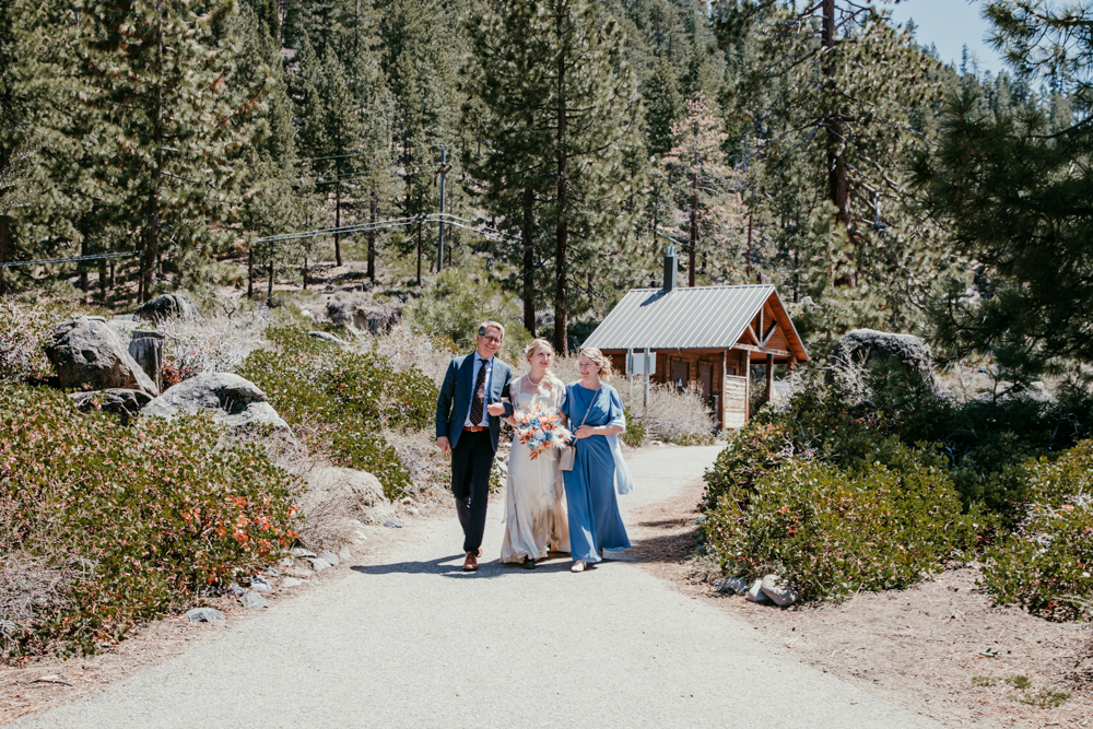 Bride walking to her Logan Shoals Vista Point elopement ceremony with her parents by her side