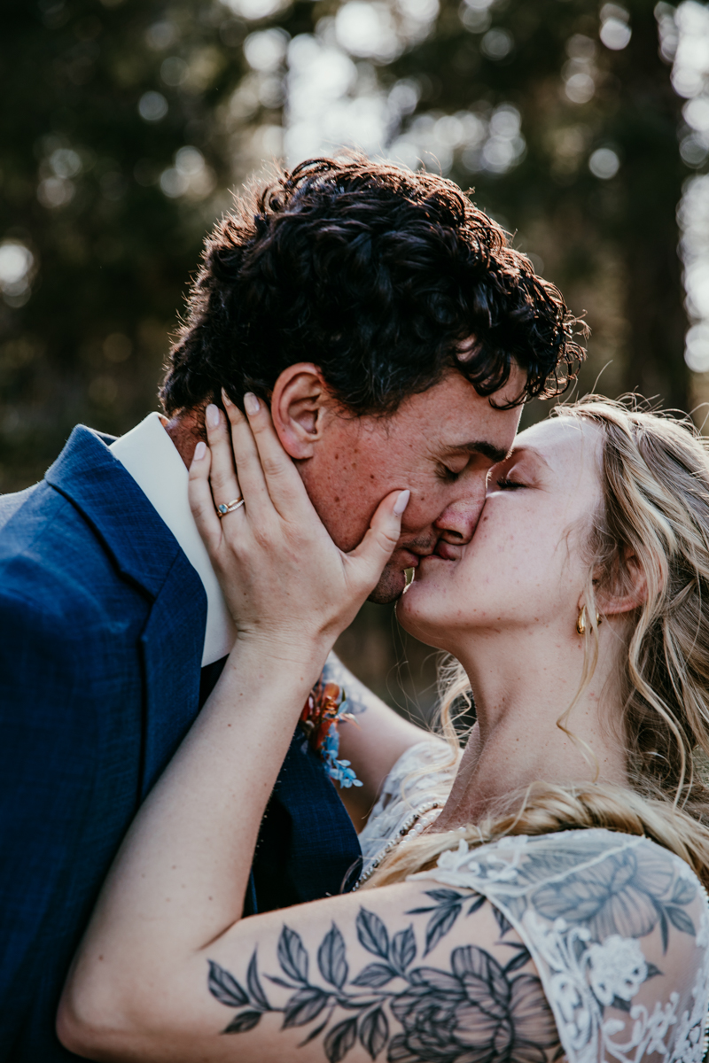 Close-up of bride and groom sharing a kiss during their Truckee elopement, hands gently holding each other’s faces with soft sunlight filtering in.