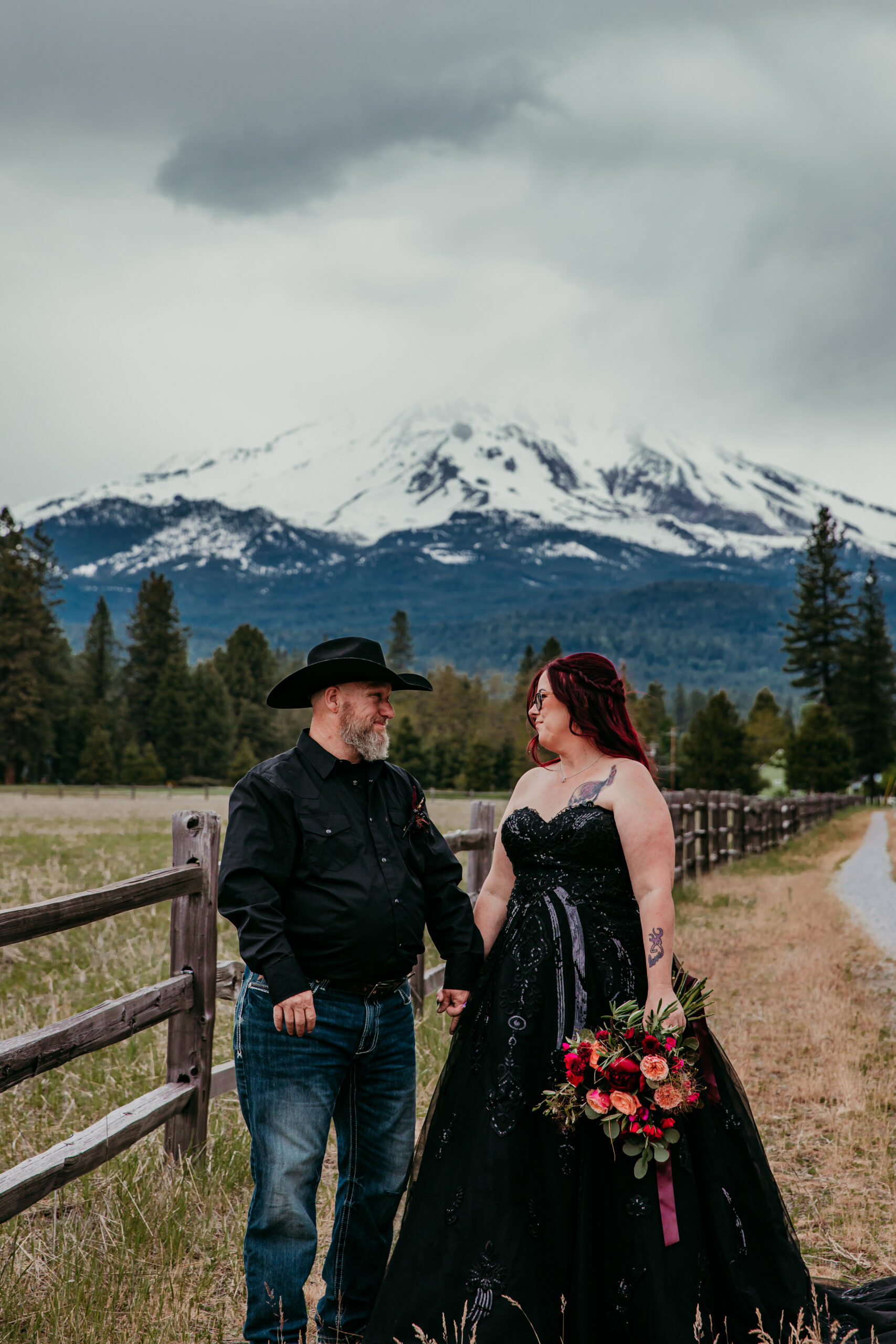 Couple standing together with Mount Shasta in the background, one of the most romantic places to elope in California, surrounded by pine trees and open fields.