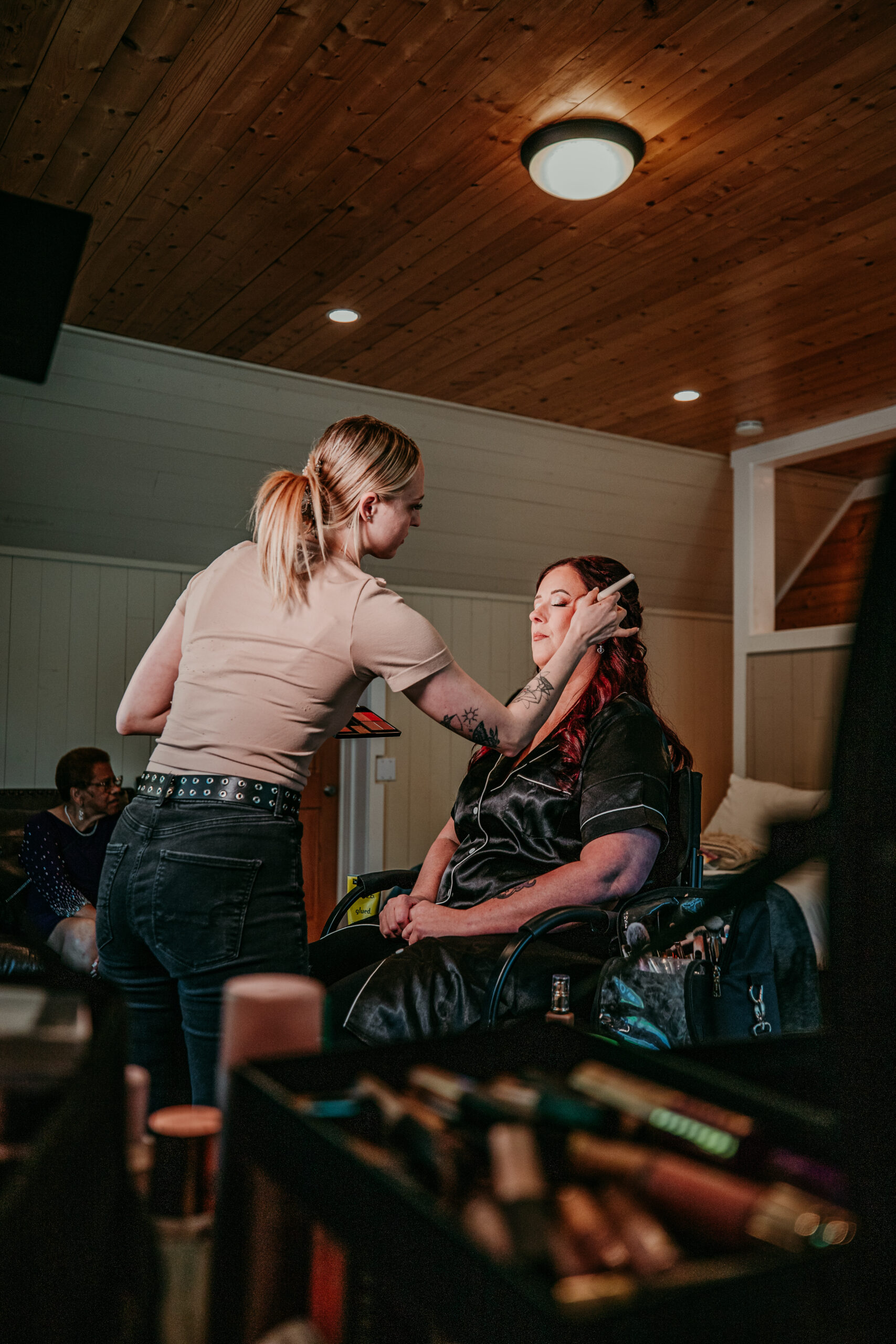 Bride getting her makeup done before eloping in Mount Shasta, captured during a relaxed morning with her wedding party.