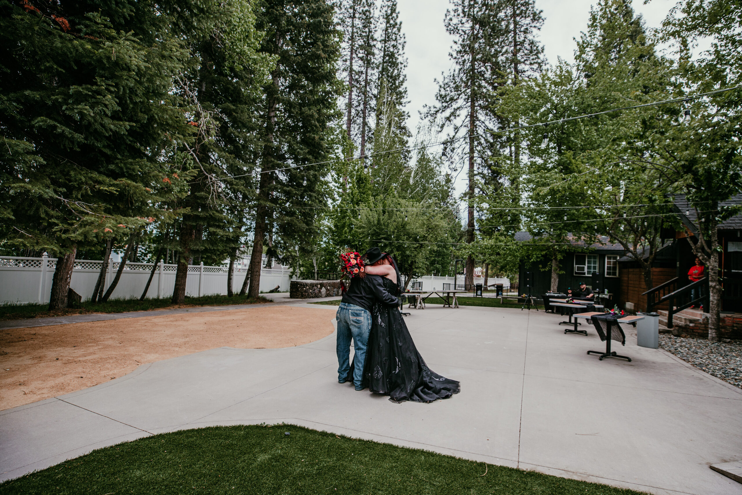 Bride and groom embracing in a quiet courtyard surrounded by trees after their ceremony while eloping in Mount Shasta.