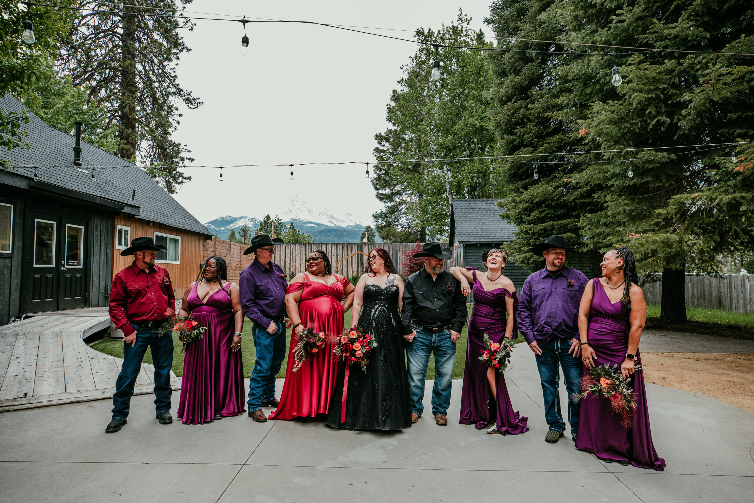 Bride and groom standing with their wedding party at Shasta View Lodge, captured during a fun group photo while eloping in Mount Shasta.