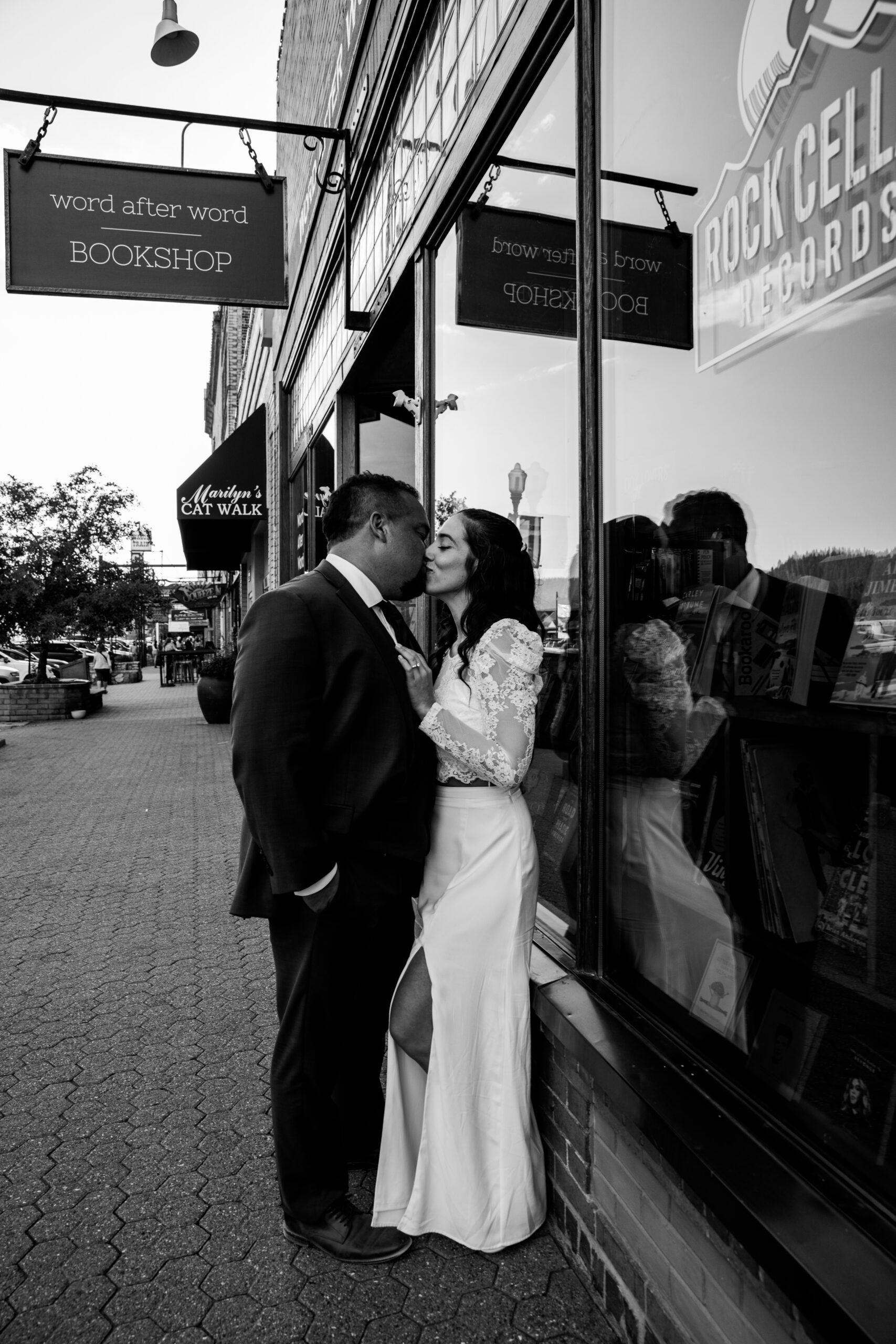 Bride and groom sharing a kiss against a shop window in downtown Truckee during their Lake Tahoe elopement.
