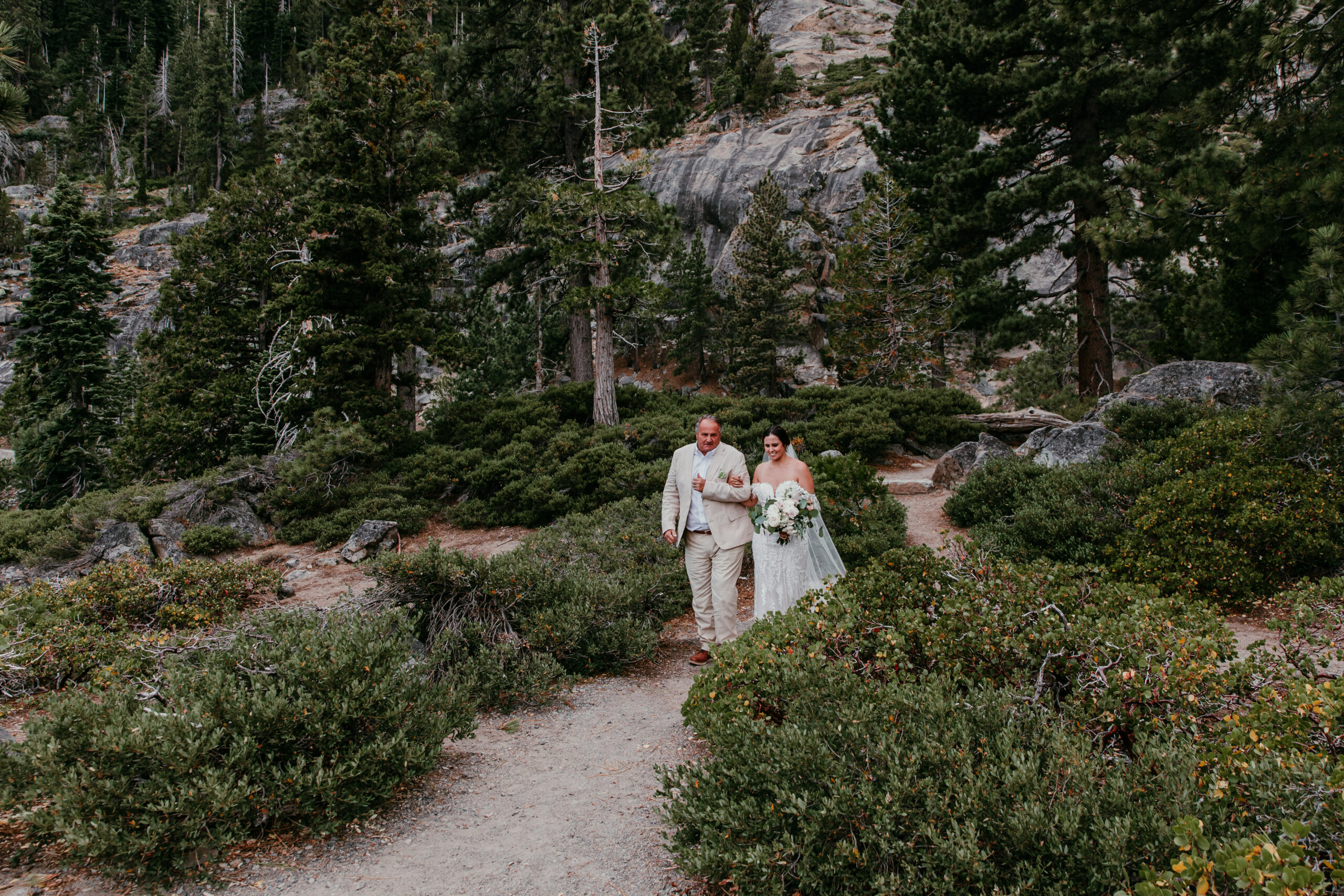 Father of the bride walking bride through forest trail to her small wedding, relaxed and intentional outdoor experience