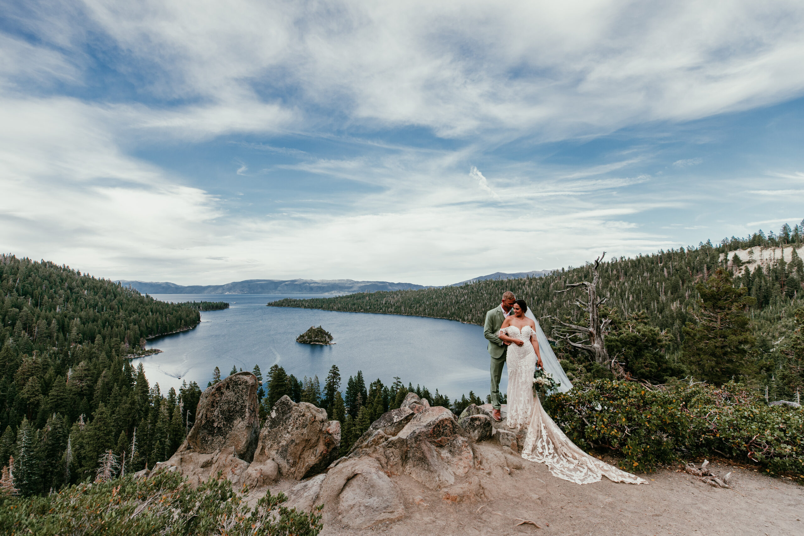 Couple standing on a cliff overlooking Emerald Bay in Lake Tahoe during their Lake Tahoe elopement.