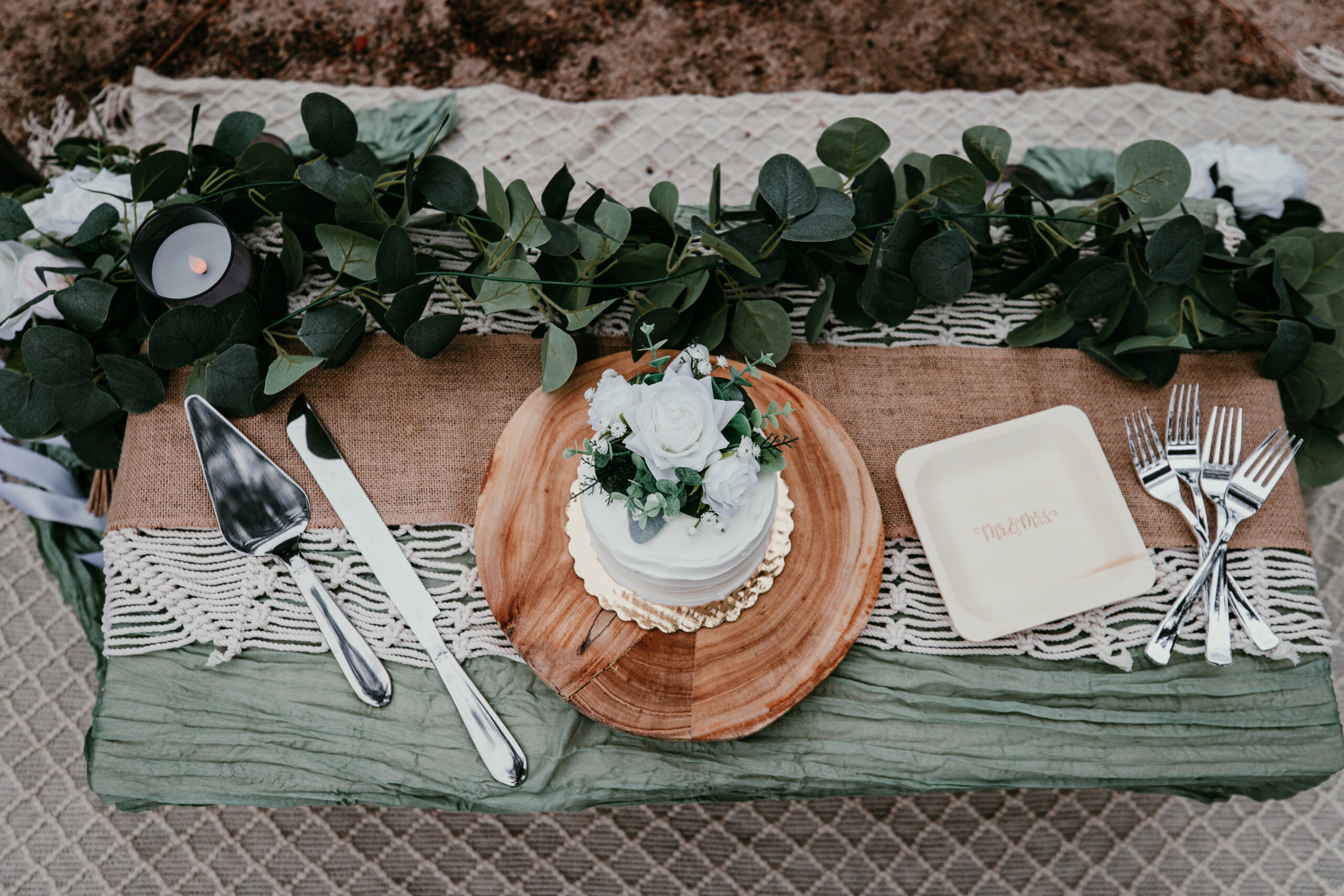 Mini wedding cake with faux florals and greenery as part of a styled picnic setup included in Lake Tahoe elopement packages — perfect for a romantic cake cutting and toast after your ceremony.