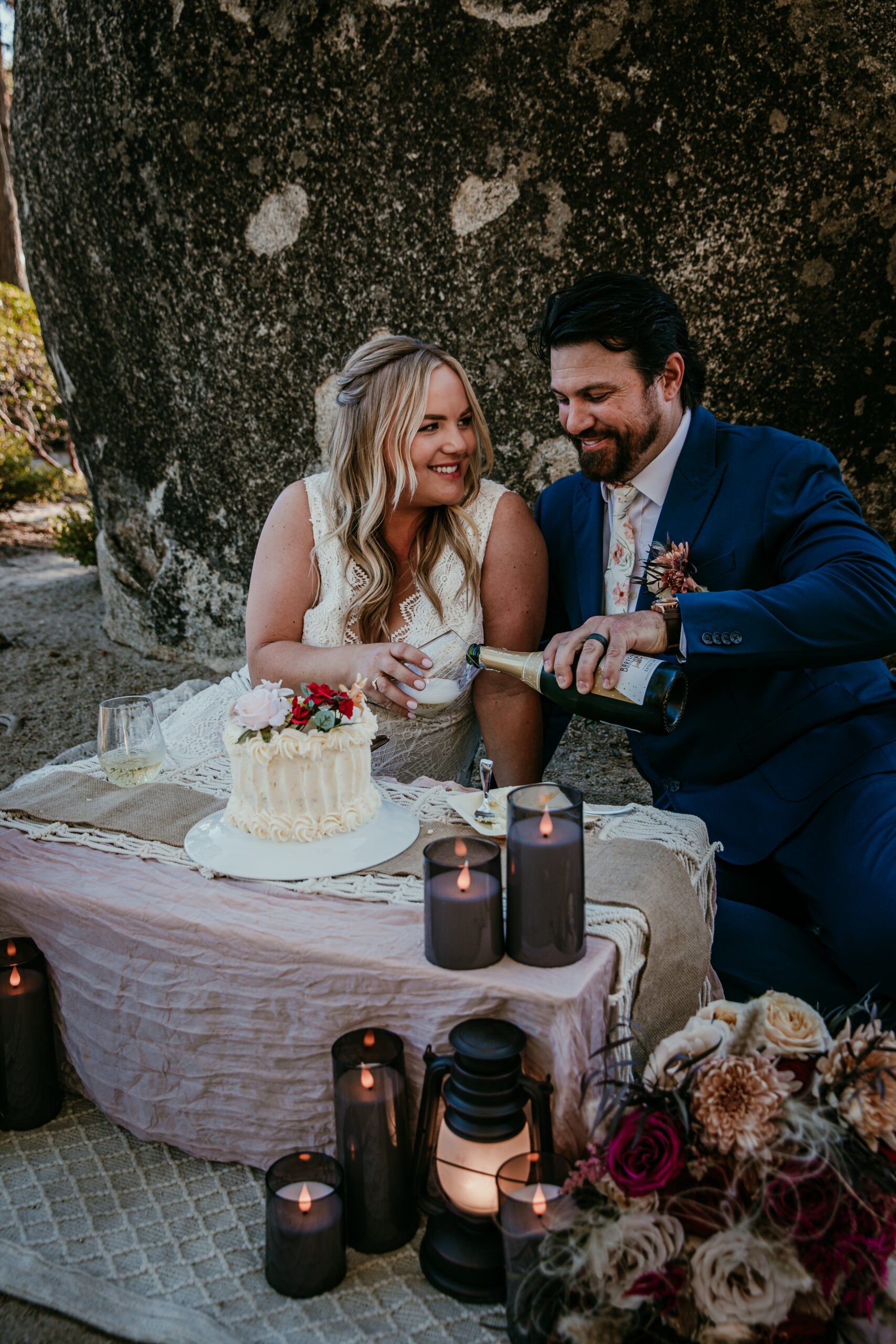 Couple celebrating their Lake Tahoe elopement with champagne and a mini cake picnic, showing why summer is one of the best times to elope in Lake Tahoe for relaxed and joyful moments.