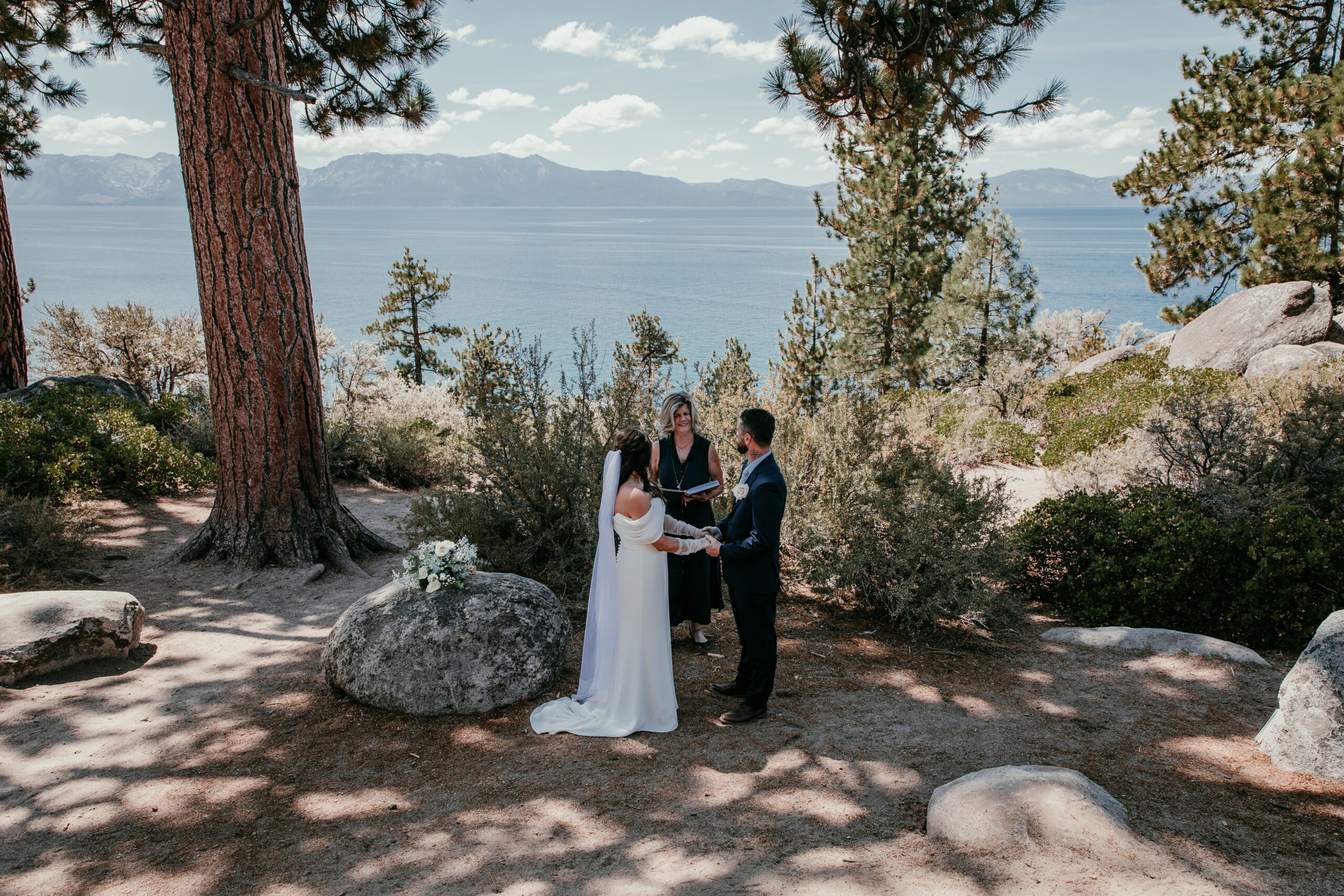 Couple exchanging vows at Logan Shoals with Lake Tahoe views during their elopement Lake Tahoe.