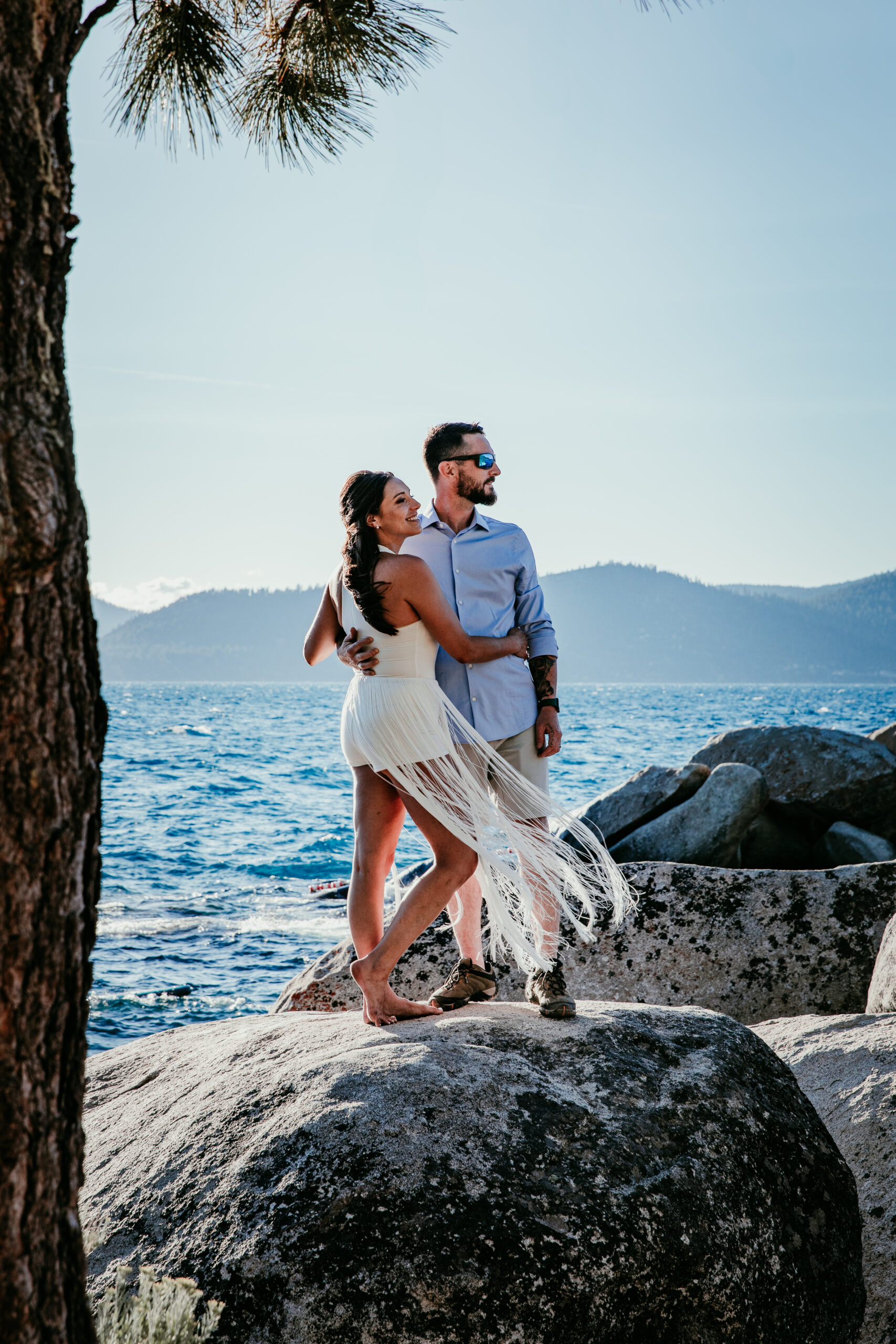 Bride and groom embracing on the rocks at Sand Harbor with lake views during their elopement Lake Tahoe.