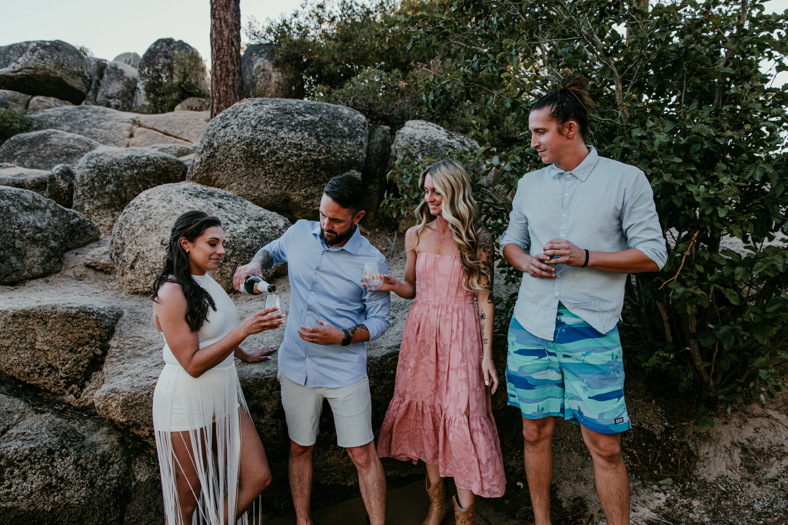 Couple pouring sparkling apple cider with friends at Sand Harbor during their elopement Lake Tahoe celebration.