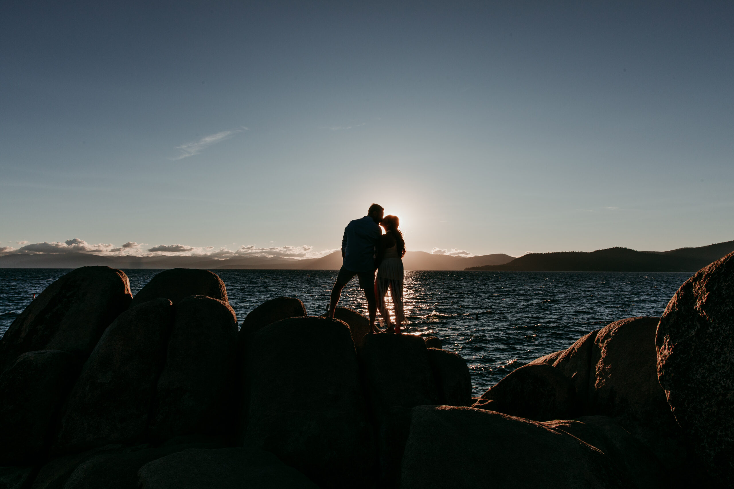 Silhouette of couple kissing on the rocks at Sand Harbor during their sunset elopement Lake Tahoe.