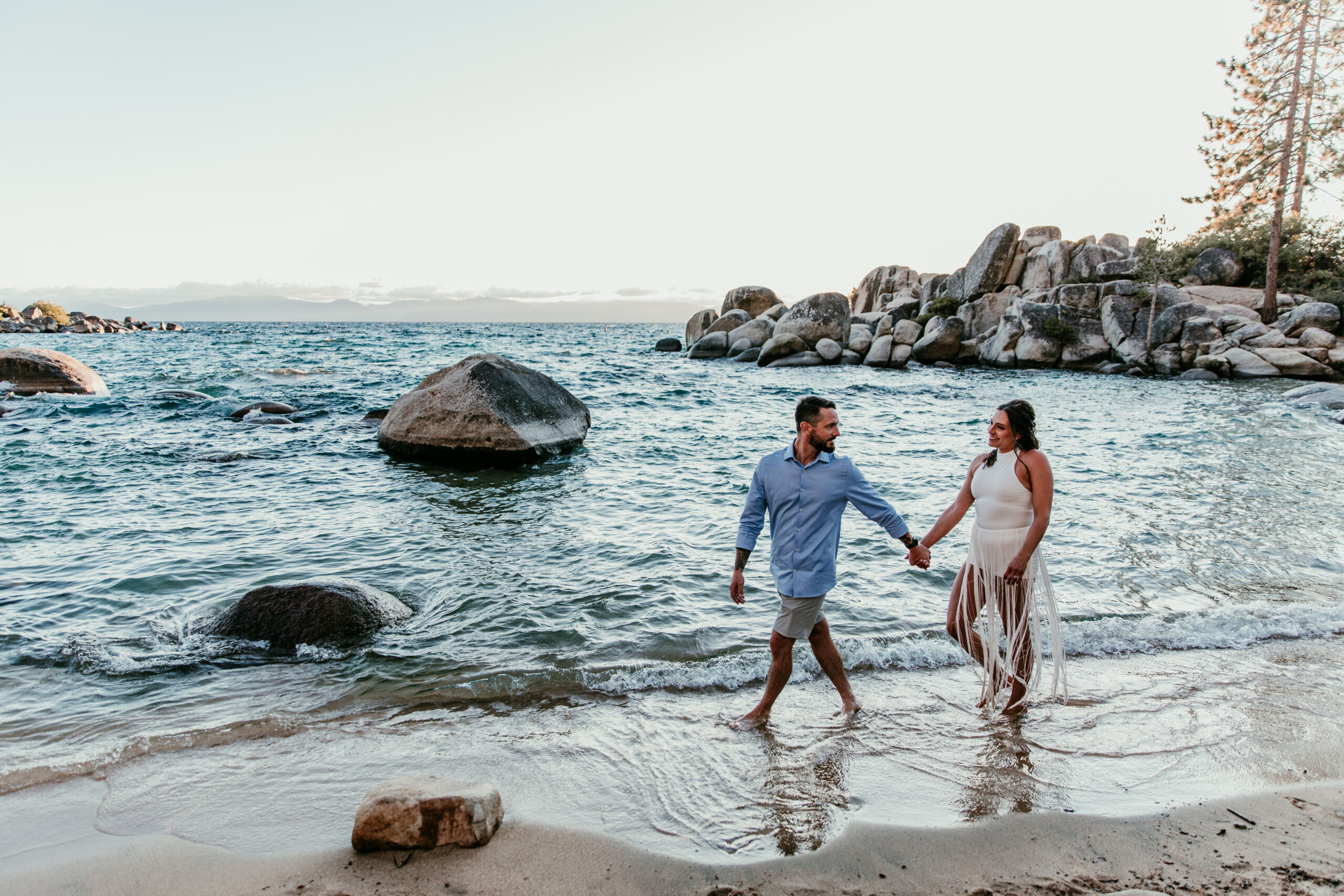 Couple walking hand in hand through the waves at Sand Harbor during their elopement Lake Tahoe.