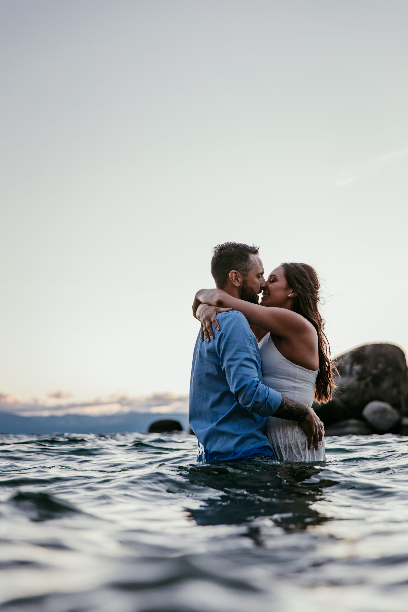Couple kissing waist-deep in the water at Sand Harbor during their sunset elopement Lake Tahoe.