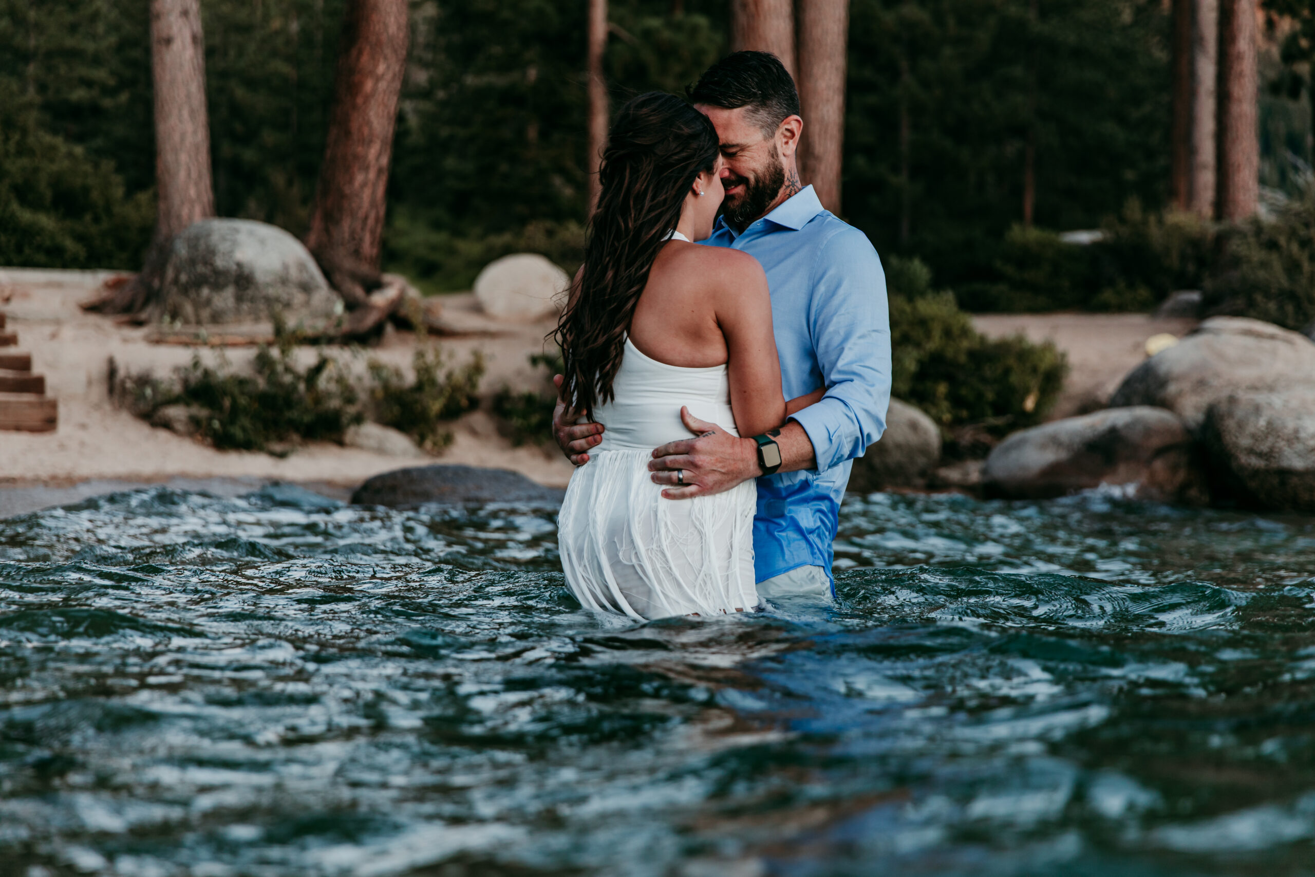 Bride and groom embracing in the lake with forest views during their elopement Lake Tahoe.