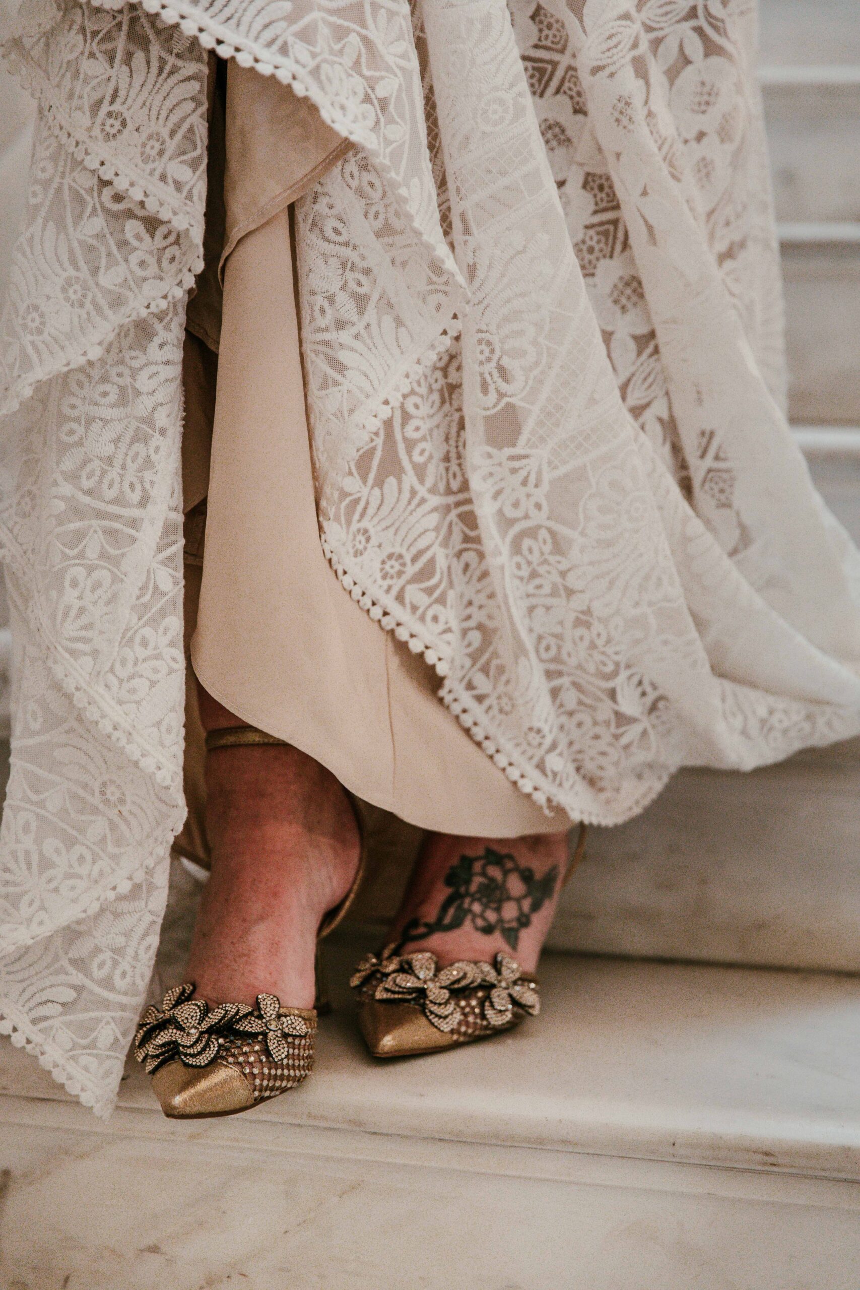 Close-up of the bride’s embellished heels and lace wedding dress during her San Francisco City Hall elopement, captured by a san francisco elopement photographer.