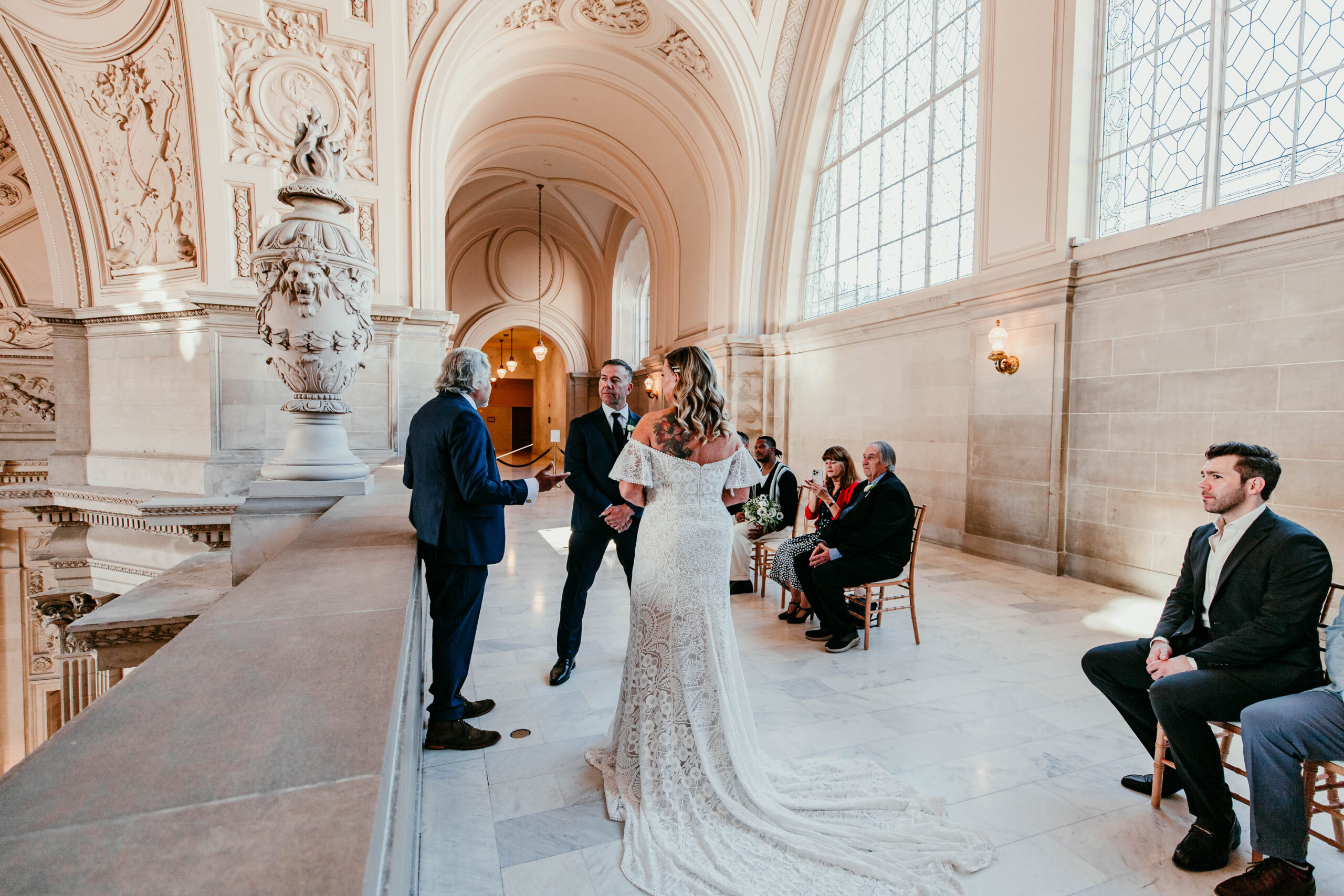 Bride and groom exchanging vows on the Fourth Floor balcony inside San Francisco City Hall during their intimate elopement, captured by a san francisco elopement photographer.