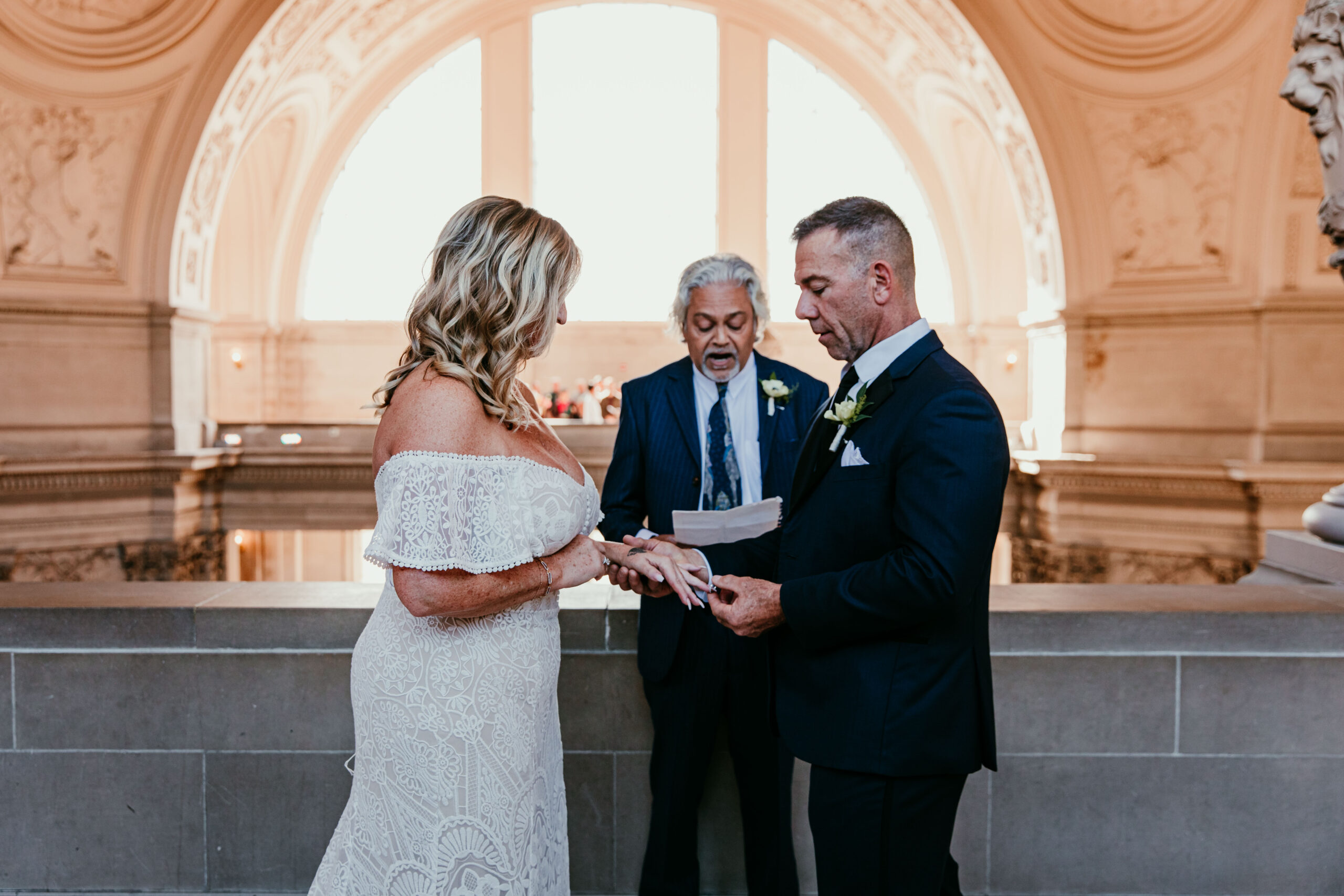 Close-up of the couple holding hands and reading vows during their San Francisco City Hall elopement, photographed by a san francisco elopement photographer.
