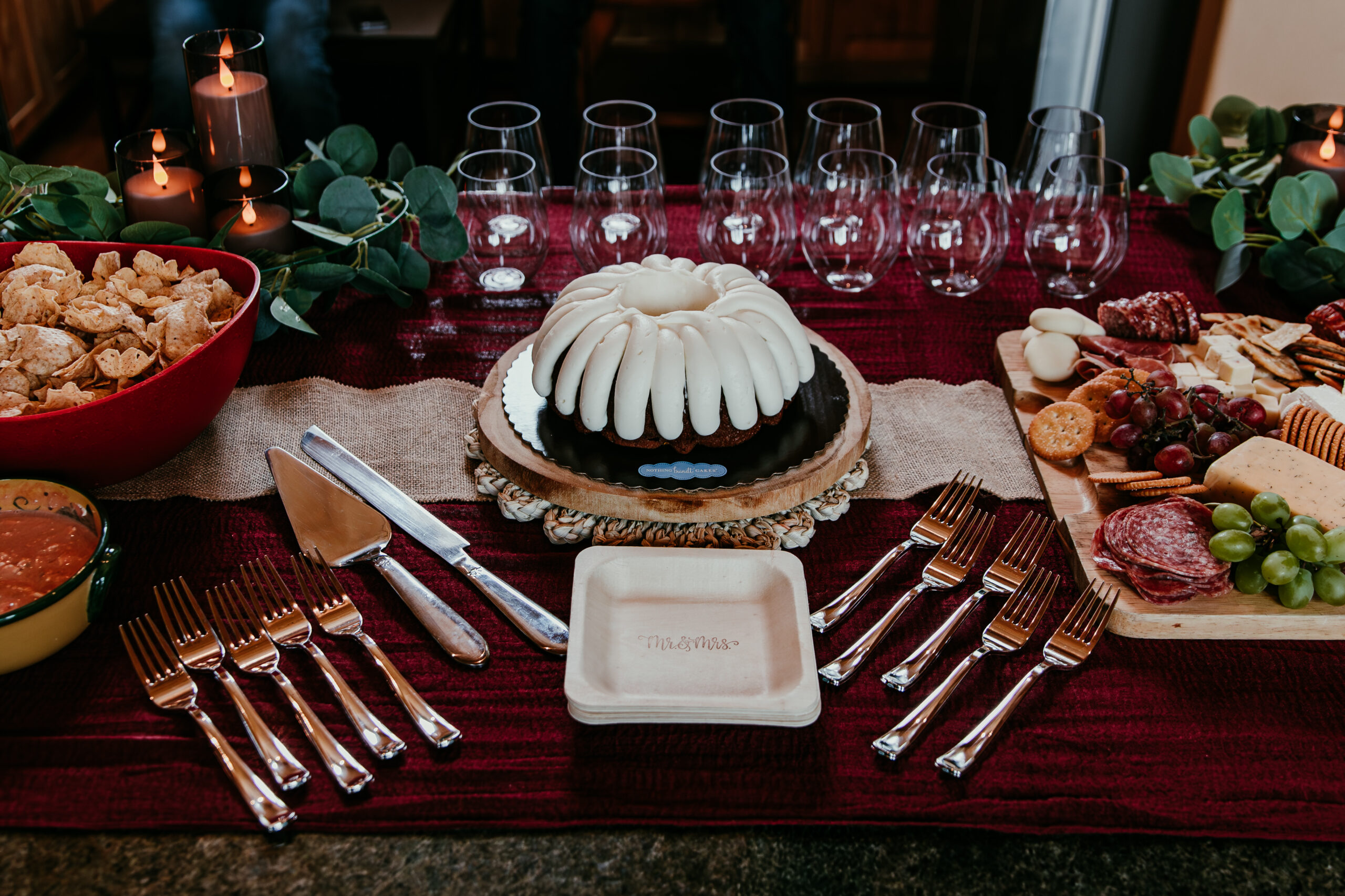 Intimate elopement reception table with nothing bundt cake, charcuterie, and champagne set up after a Lake Tahoe elopement, captured in cozy lake tahoe elopement photos indoors