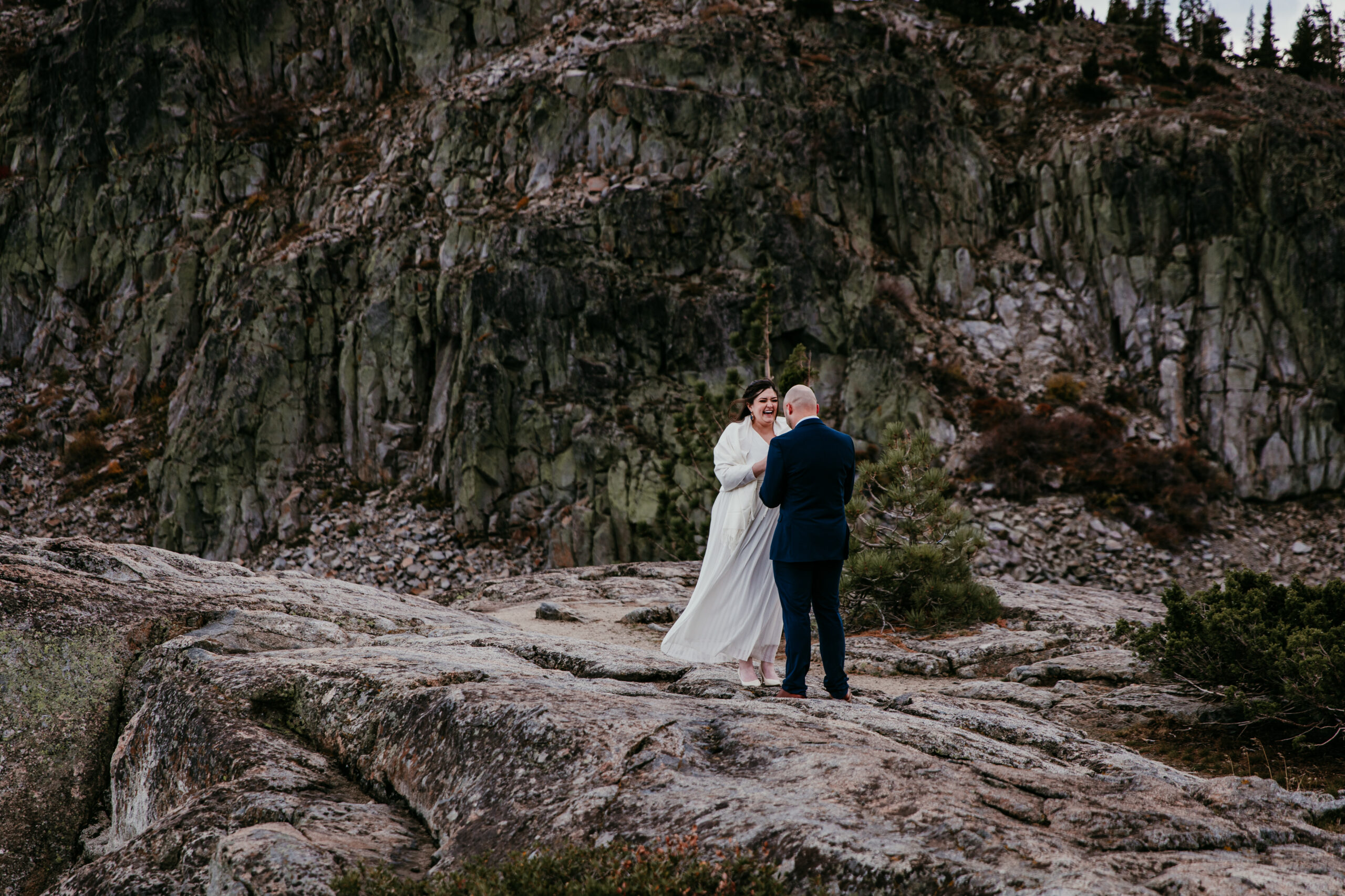 Couple exchanging vows on a rocky overlook during a private elopement ceremony, illustrating why couples research what states allow self-solemnization.