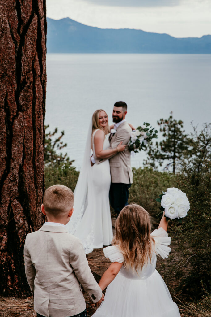 Children walking toward parents during Lake Tahoe elopement with mountain lake backdrop