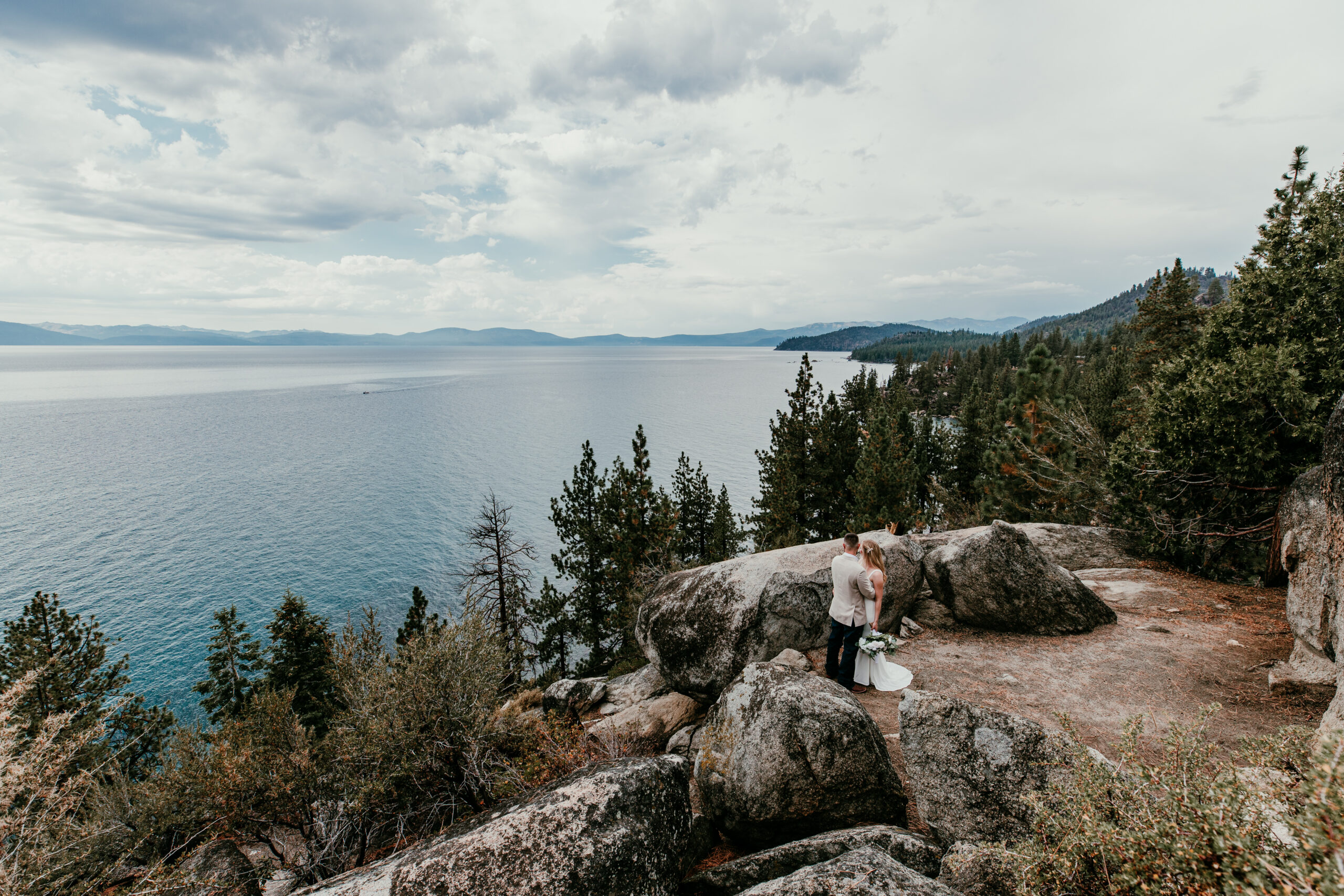 Couple standing on a cliff overlooking Lake Tahoe during an intimate elopement, showing why couples don’t regret eloping instead of having a wedding
