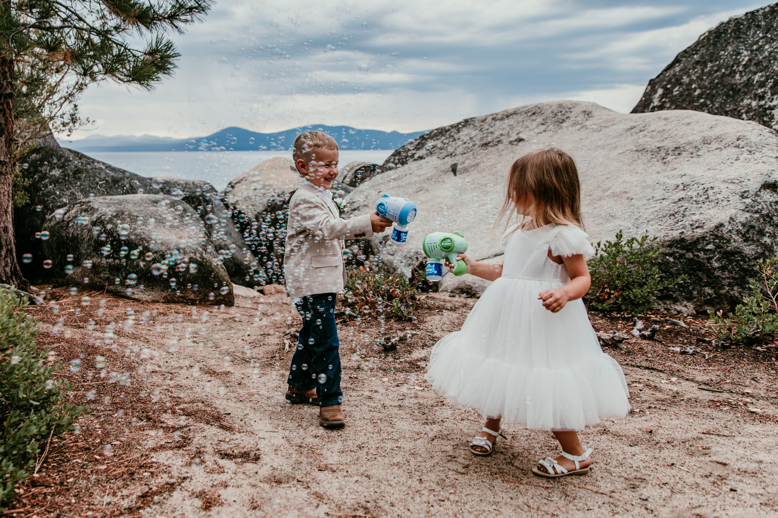 Children playing with bubbles during small wedding, fun and natural moment in outdoor setting