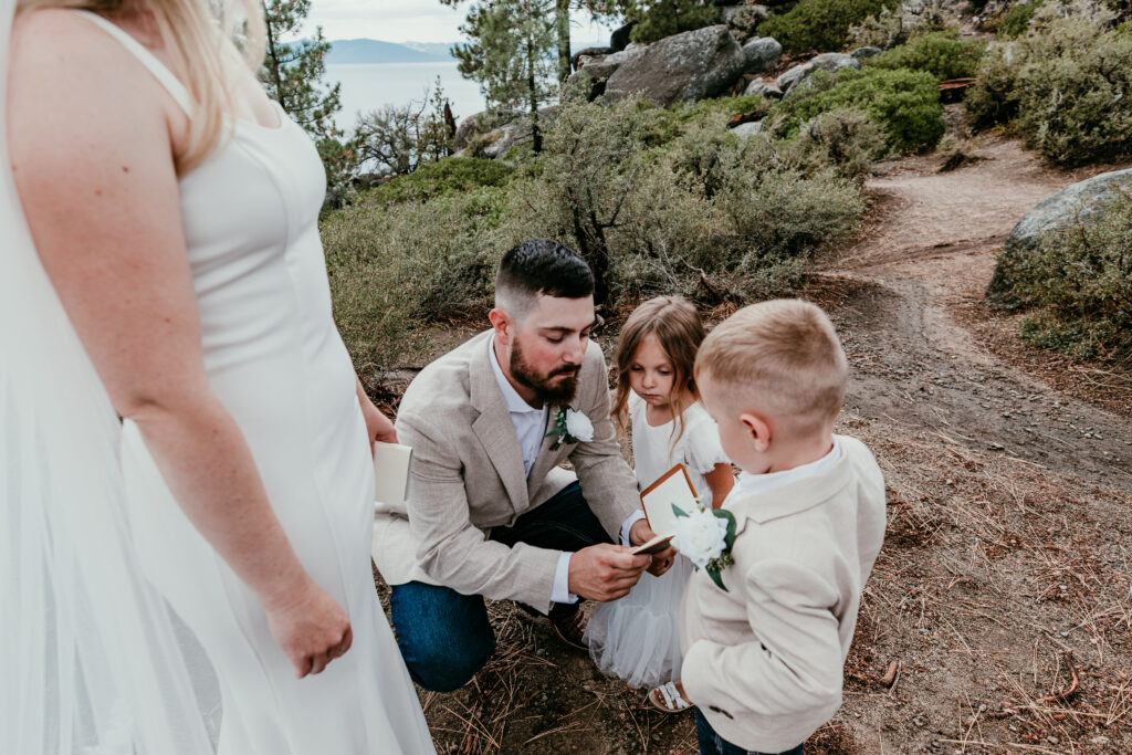 Groom kneeling with children during Lake Tahoe blended family elopement ceremony at Logan Shoals