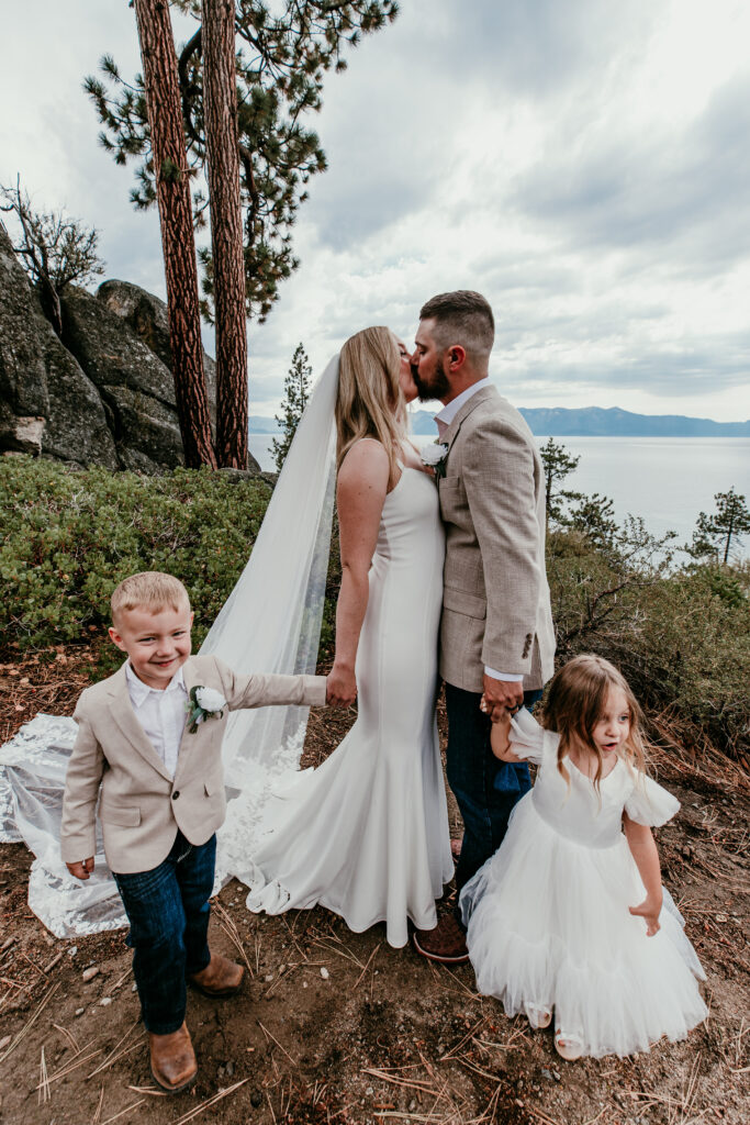 Lake Tahoe blended family elopement portrait at Logan Shoals with couple kissing and children beside them