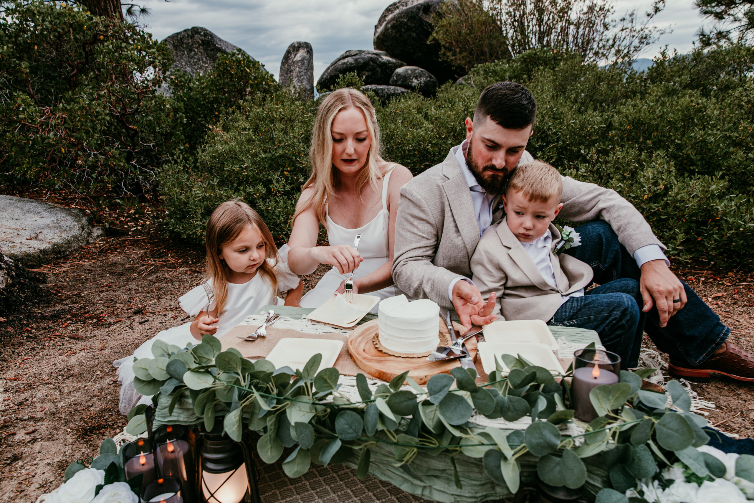Blended family sharing cake during Lake Tahoe elopement celebration by the lake