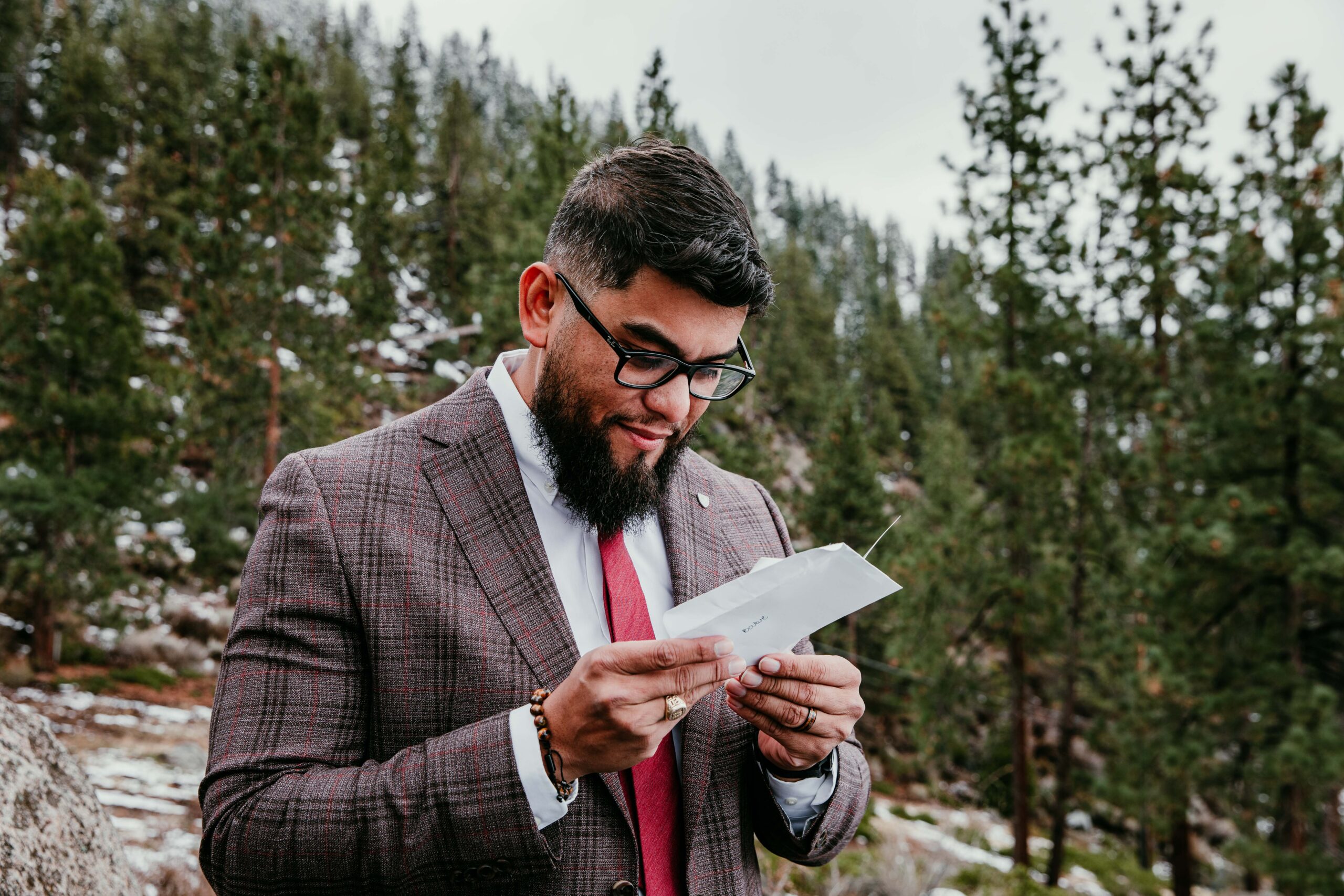Groom reading a handwritten letter during a Lake Tahoe winter elopement before the ceremony at Logan Shoals Vista Point.