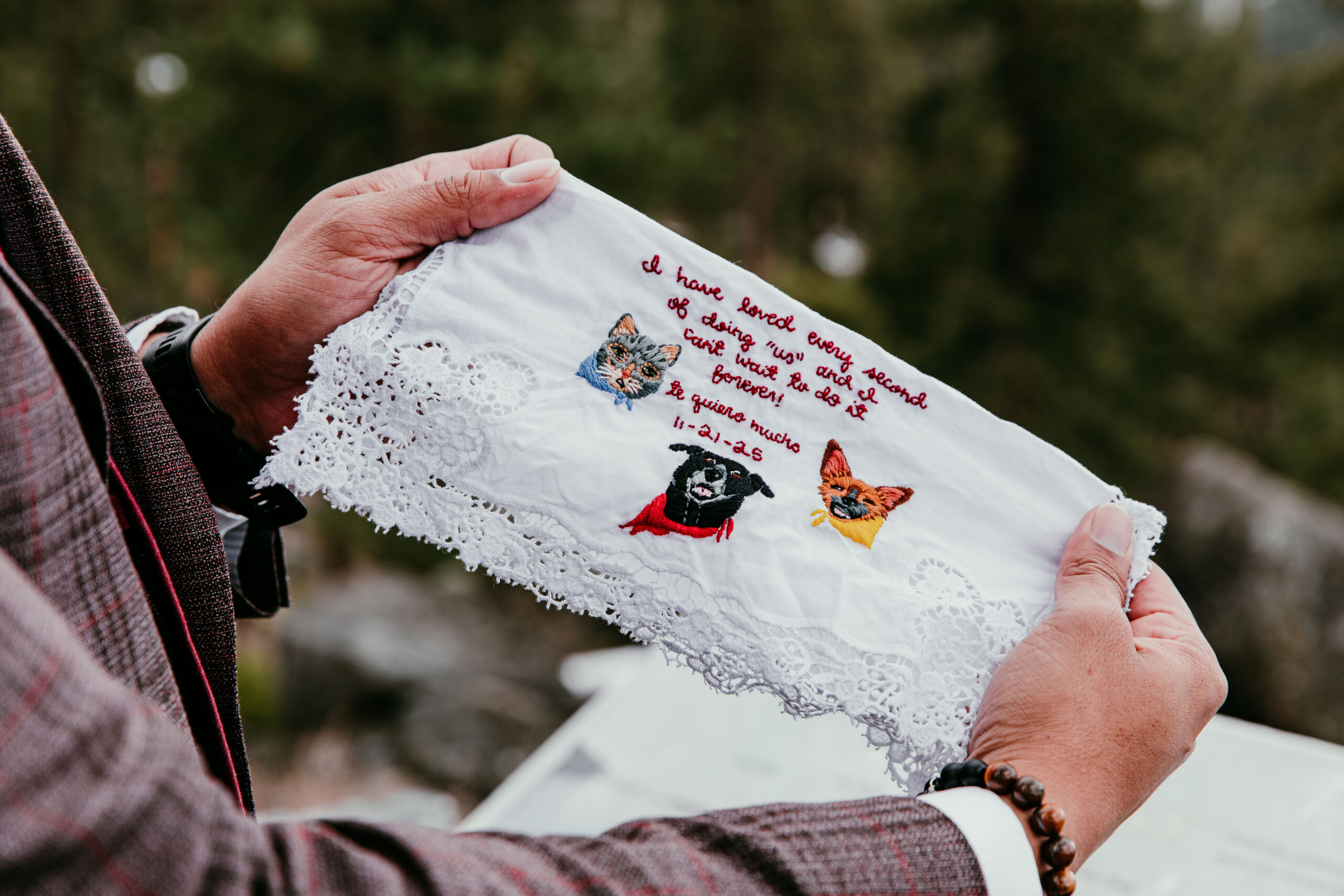 Close-up of embroidered handkerchief gift featuring the couple’s pets during their Lake Tahoe winter elopement.