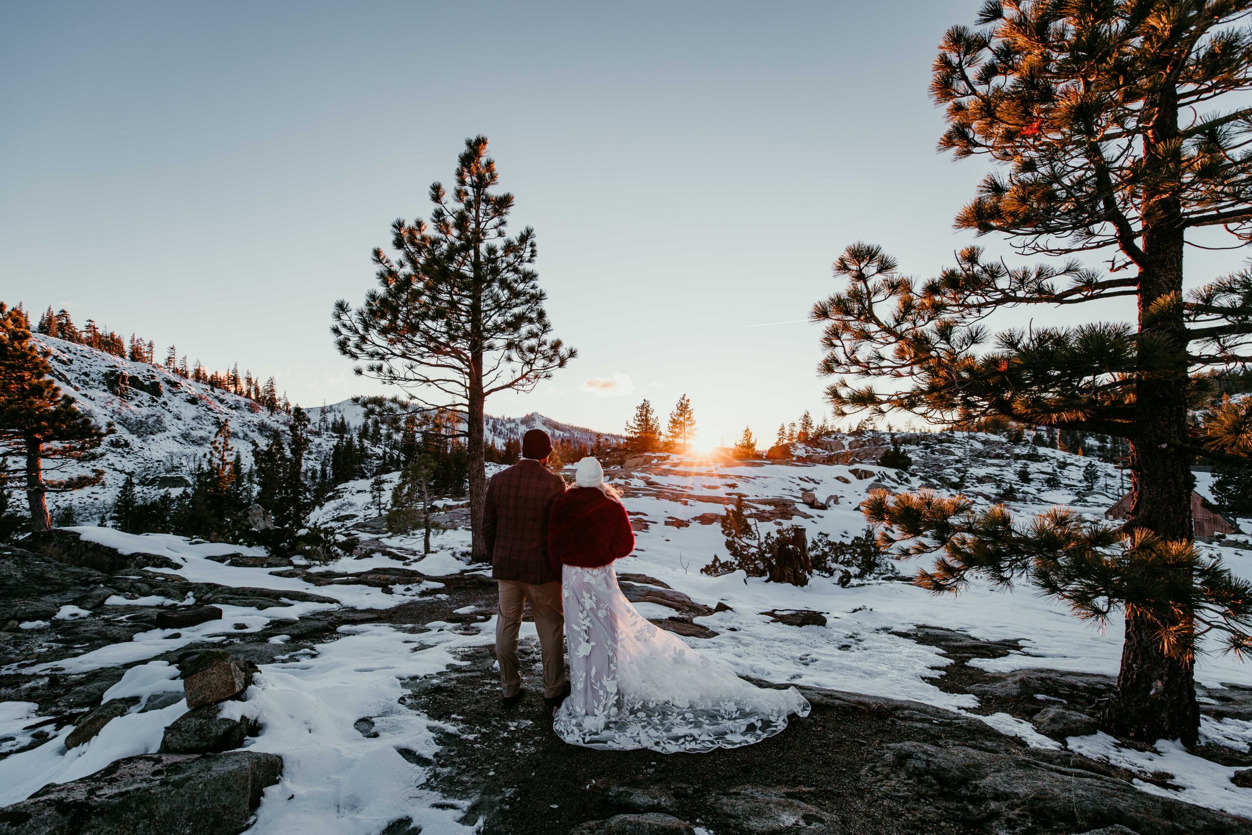 Couple standing together at sunset during their snowy winter elopement at Donner Summit.