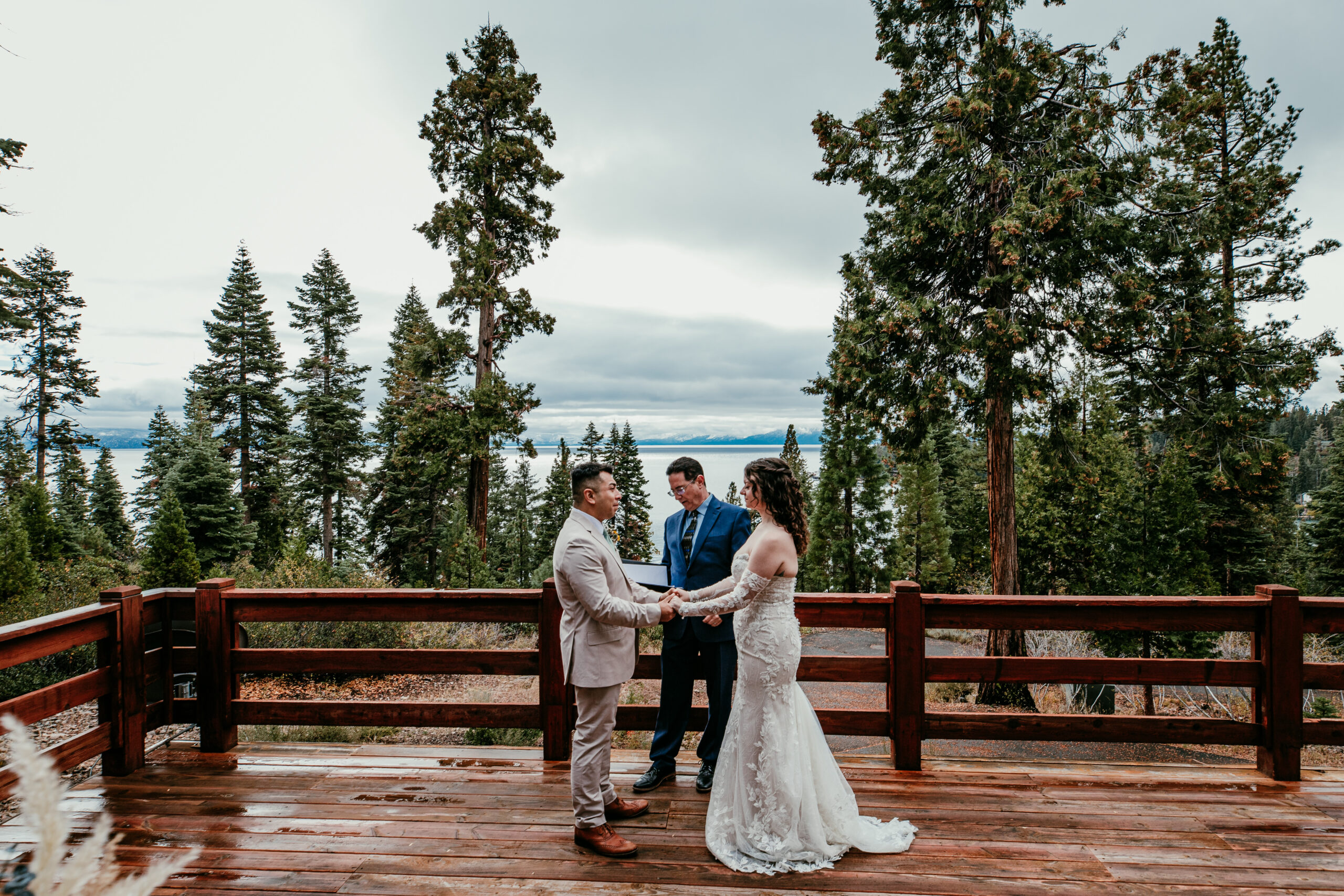 Bride and groom holding hands during their intimate Lake Tahoe elopement ceremony with mountain views in the background.