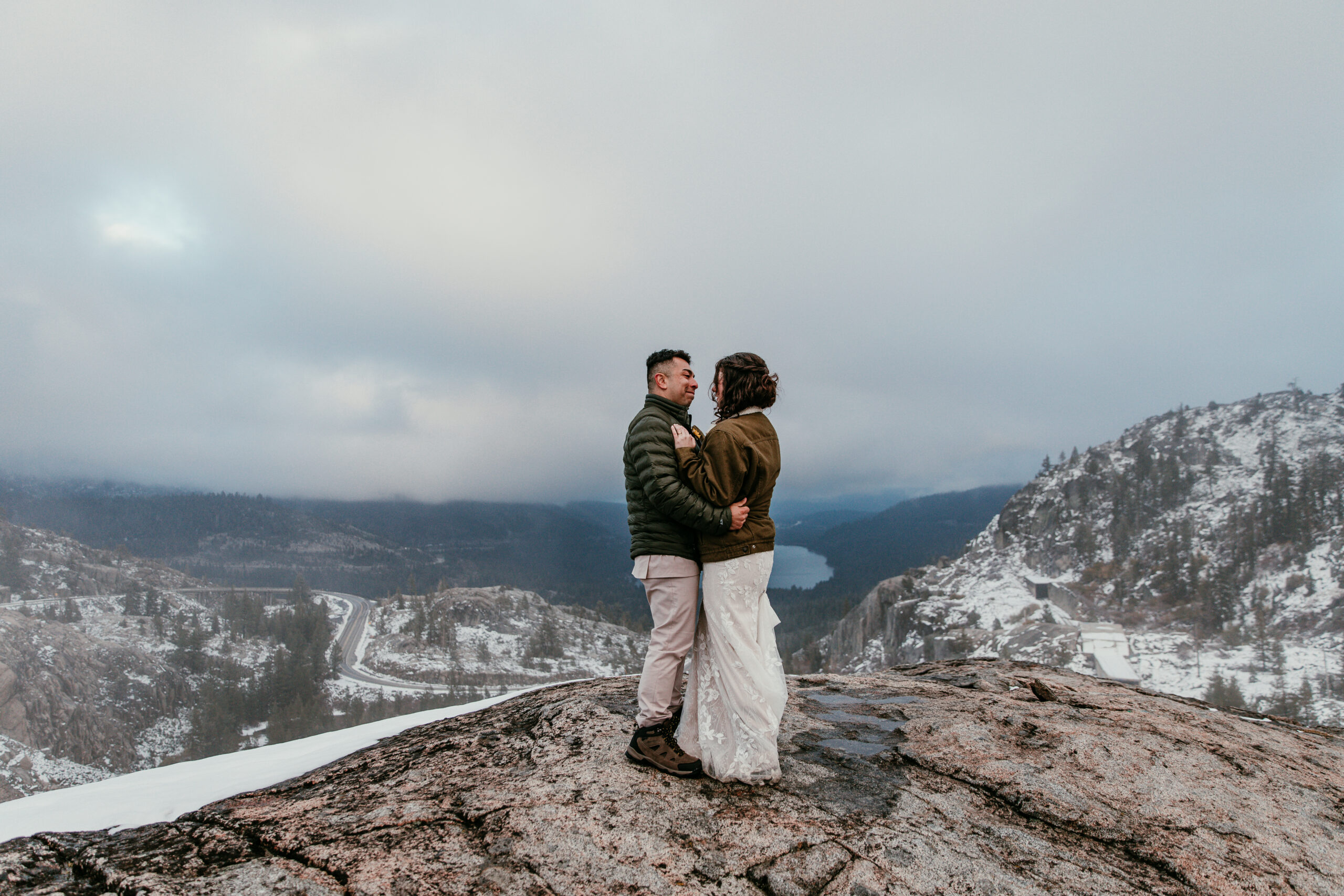 Bride and groom holding each other close on a snowy mountain during their Lake Tahoe elopement.